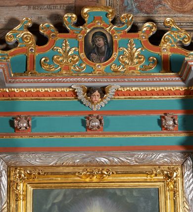 Zdjęcie nr 4: Ołtarz przyścienny, architektoniczny, jednokondygnacyjny, jednoosiowy, z niewielkim zwieńczeniem. Mensa drewniana na murowanej prostopadłościennej skrzyni. Retabulum z wydzieloną predellą ujętą po bokach konsolkami. Boki nastawy w wycięte w formie uproszczonych wolut. Nastawa ujęta parą ustawionych na tle pilastrów kolumn o kompozytowych kapitelach i trzonach dekorowanych w 3/4 wysokości ornamentem okuciowym, powyżej wicią roślinną. Kolumny, ustawione na konsolach zdobionych na krawędziach ornamentem cekinowym, wspierają występujące nad nimi belkowanie i gzyms. Zwieńczenie o fantazyjnym wykroju. W polu środkowym prostokątna nisza ujęta podwójną ramą: zewnętrzna srebrzona, formowana z motywów liści akantu, wewnętrzna profilowana z aplikowanym ornamentem rocaille'owym. W niszy obraz z przedstawieniem Najświętszego Serca Jezusa. Predella dekorowana trzema płycinami, z których boczne wypełnione malowanymi obrazami: Zwiastowanie NMP po lewej i Boże Narodzenie po prawej stronie. W zwieńczeniu owalny obraz z przedstawieniem Matki Boskiej Bolesnej. Konsole kolumn i flankujące nastawę dekorowane na krawędziach ornamentem cekinowym i wolutowo skręconą wicią roślinną. Belkowanie zdobione rozetami w partii fryzu, pośrodku aplikowana rzeźbiona uskrzydlona główka anielska. Całość struktury polichromowana w dwóch odcieniach: jasnobłękitnym oraz brązowym, detal architektoniczny i profilowania złocone i srebrzone.