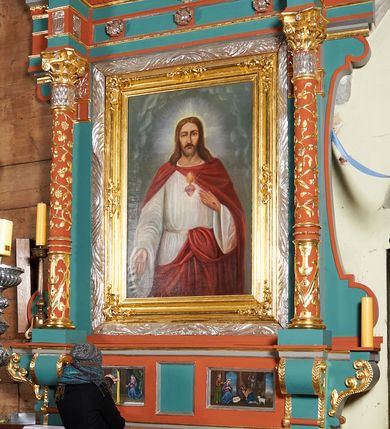 Zdjęcie nr 2: Ołtarz przyścienny, architektoniczny, jednokondygnacyjny, jednoosiowy, z niewielkim zwieńczeniem. Mensa drewniana na murowanej prostopadłościennej skrzyni. Retabulum z wydzieloną predellą ujętą po bokach konsolkami. Boki nastawy w wycięte w formie uproszczonych wolut. Nastawa ujęta parą ustawionych na tle pilastrów kolumn o kompozytowych kapitelach i trzonach dekorowanych w 3/4 wysokości ornamentem okuciowym, powyżej wicią roślinną. Kolumny, ustawione na konsolach zdobionych na krawędziach ornamentem cekinowym, wspierają występujące nad nimi belkowanie i gzyms. Zwieńczenie o fantazyjnym wykroju. W polu środkowym prostokątna nisza ujęta podwójną ramą: zewnętrzna srebrzona, formowana z motywów liści akantu, wewnętrzna profilowana z aplikowanym ornamentem rocaille'owym. W niszy obraz z przedstawieniem Najświętszego Serca Jezusa. Predella dekorowana trzema płycinami, z których boczne wypełnione malowanymi obrazami: Zwiastowanie NMP po lewej i Boże Narodzenie po prawej stronie. W zwieńczeniu owalny obraz z przedstawieniem Matki Boskiej Bolesnej. Konsole kolumn i flankujące nastawę dekorowane na krawędziach ornamentem cekinowym i wolutowo skręconą wicią roślinną. Belkowanie zdobione rozetami w partii fryzu, pośrodku aplikowana rzeźbiona uskrzydlona główka anielska. Całość struktury polichromowana w dwóch odcieniach: jasnobłękitnym oraz brązowym, detal architektoniczny i profilowania złocone i srebrzone.