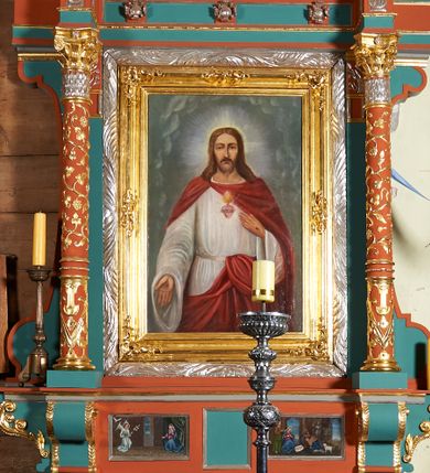 Zdjęcie nr 1: Ołtarz przyścienny, architektoniczny, jednokondygnacyjny, jednoosiowy, z niewielkim zwieńczeniem. Mensa drewniana na murowanej prostopadłościennej skrzyni. Retabulum z wydzieloną predellą ujętą po bokach konsolkami. Boki nastawy w wycięte w formie uproszczonych wolut. Nastawa ujęta parą ustawionych na tle pilastrów kolumn o kompozytowych kapitelach i trzonach dekorowanych w 3/4 wysokości ornamentem okuciowym, powyżej wicią roślinną. Kolumny, ustawione na konsolach zdobionych na krawędziach ornamentem cekinowym, wspierają występujące nad nimi belkowanie i gzyms. Zwieńczenie o fantazyjnym wykroju. W polu środkowym prostokątna nisza ujęta podwójną ramą: zewnętrzna srebrzona, formowana z motywów liści akantu, wewnętrzna profilowana z aplikowanym ornamentem rocaille'owym. W niszy obraz z przedstawieniem Najświętszego Serca Jezusa. Predella dekorowana trzema płycinami, z których boczne wypełnione malowanymi obrazami: Zwiastowanie NMP po lewej i Boże Narodzenie po prawej stronie. W zwieńczeniu owalny obraz z przedstawieniem Matki Boskiej Bolesnej. Konsole kolumn i flankujące nastawę dekorowane na krawędziach ornamentem cekinowym i wolutowo skręconą wicią roślinną. Belkowanie zdobione rozetami w partii fryzu, pośrodku aplikowana rzeźbiona uskrzydlona główka anielska. Całość struktury polichromowana w dwóch odcieniach: jasnobłękitnym oraz brązowym, detal architektoniczny i profilowania złocone i srebrzone.