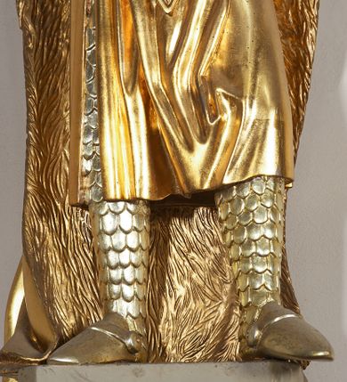 Zdjęcie nr 6: Pełnoplastyczna, drewniana figura św. Ludwika, ustawiona na konsoli. Święty został przedstawiony w pozycji stojącej, z lewą nogą wysuniętą nieco do przodu, ubrany w zbroję łuskową, na którą narzucono mu przewiązaną pasem tunikę i obfity płaszcz z futrzanym podbiciem spięty pod szyją. Prawą, ugiętą rękę opiera na biodrze, lewą wyciąga przed siebie. Twarz pociągła, okolona długimi włosami opadającymi na oba ramiona i zwijającymi się w loki. Ma niewielkie, pełne usta, prosty nos i ciemne oczy; na głowie korona zamknięta. Partie twarzy i włosów polichromowane naturalistycznie, szaty złocone. 