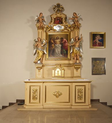 Zdjęcie nr 2: Ołtarz przyścienny, architektoniczny, jednoosiowy, jednokondygnacyjny ze zwieńczeniem. Mensa prostopadłościenna na profilowanym cokole, antepedium dekorowane trzema płycinami z plakietami z ornamentu roślinnego. Tabernakulum architektoniczne, w formie prostopadłościanu na profilowanym cokole, o ujętym wolutami wklęsło-wypukłym zwieńczeniu. Na ścianie frontowej drzwiczki w kształcie stojącego prostokąta zamkniętego łukiem nadwieszonym z uskokiem. Nastawa ołtarzowa ujęta  pilastrami z płycinami ustawionymi na wysokich cokołach, na których wspierają się konsole podtrzymujące rzeźby aniołów. Podpory dźwigają pełne, wyłamane na ich osiach belkowanie, na którym posadowiono figury aniołków. W centrum kondygnacji prostokątna nisza mieszcząca obraz „Męczeństwo św. Bartłomieja”, ujęta prostokątną ramą dekorowaną w czterech miejscach kwitnącymi różami z liśćmi. Między polem obrazowym a belkowaniem kondygnacji unoszony przez dwa anioły kartusz z inskrypcją „ŚWIĘTY / BARTŁOMIEJU / MÓDL SIĘ / ZA NAMI”. Zwieńczenie o kształcie wklęsło-wypukłym, ujęte ulistnionymi wolutami, wypełnione obrazem powtarzającym jego kształt, przedstawiającym Jezusa Chrystusa. Na szczycie krzyż równoramienny o ramionach zakończonych trójlistnie, na tle glorii.  Struktura ołtarza w kolorze kremowym; profile, detale i ornamenty złocone i srebrzone.