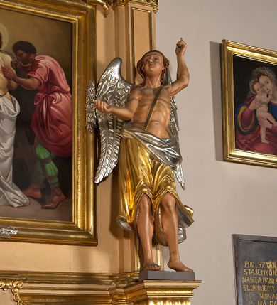 Zdjęcie nr 7: Ołtarz przyścienny, architektoniczny, jednoosiowy, jednokondygnacyjny ze zwieńczeniem. Mensa prostopadłościenna na profilowanym cokole, antepedium dekorowane trzema płycinami z plakietami z ornamentu roślinnego. Tabernakulum architektoniczne, w formie prostopadłościanu na profilowanym cokole, o ujętym wolutami wklęsło-wypukłym zwieńczeniu. Na ścianie frontowej drzwiczki w kształcie stojącego prostokąta zamkniętego łukiem nadwieszonym z uskokiem. Nastawa ołtarzowa ujęta  pilastrami z płycinami ustawionymi na wysokich cokołach, na których wspierają się konsole podtrzymujące rzeźby aniołów. Podpory dźwigają pełne, wyłamane na ich osiach belkowanie, na którym posadowiono figury aniołków. W centrum kondygnacji prostokątna nisza mieszcząca obraz „Męczeństwo św. Bartłomieja”, ujęta prostokątną ramą dekorowaną w czterech miejscach kwitnącymi różami z liśćmi. Między polem obrazowym a belkowaniem kondygnacji unoszony przez dwa anioły kartusz z inskrypcją „ŚWIĘTY / BARTŁOMIEJU / MÓDL SIĘ / ZA NAMI”. Zwieńczenie o kształcie wklęsło-wypukłym, ujęte ulistnionymi wolutami, wypełnione obrazem powtarzającym jego kształt, przedstawiającym Jezusa Chrystusa. Na szczycie krzyż równoramienny o ramionach zakończonych trójlistnie, na tle glorii.  Struktura ołtarza w kolorze kremowym; profile, detale i ornamenty złocone i srebrzone.