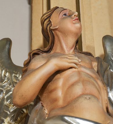 Zdjęcie nr 16: Ołtarz przyścienny, architektoniczny, jednoosiowy, jednokondygnacyjny ze zwieńczeniem. Mensa prostopadłościenna na profilowanym cokole, antepedium dekorowane trzema płycinami z plakietami z ornamentu roślinnego. Tabernakulum architektoniczne, w formie prostopadłościanu na profilowanym cokole, o ujętym wolutami wklęsło-wypukłym zwieńczeniu. Na ścianie frontowej drzwiczki w kształcie stojącego prostokąta zamkniętego łukiem nadwieszonym z uskokiem. Nastawa ołtarzowa ujęta  pilastrami z płycinami ustawionymi na wysokich cokołach, na których wspierają się konsole podtrzymujące rzeźby aniołów. Podpory dźwigają pełne, wyłamane na ich osiach belkowanie, na którym posadowiono figury aniołków. W centrum kondygnacji prostokątna nisza mieszcząca obraz „Męczeństwo św. Bartłomieja”, ujęta prostokątną ramą dekorowaną w czterech miejscach kwitnącymi różami z liśćmi. Między polem obrazowym a belkowaniem kondygnacji unoszony przez dwa anioły kartusz z inskrypcją „ŚWIĘTY / BARTŁOMIEJU / MÓDL SIĘ / ZA NAMI”. Zwieńczenie o kształcie wklęsło-wypukłym, ujęte ulistnionymi wolutami, wypełnione obrazem powtarzającym jego kształt, przedstawiającym Jezusa Chrystusa. Na szczycie krzyż równoramienny o ramionach zakończonych trójlistnie, na tle glorii.  Struktura ołtarza w kolorze kremowym; profile, detale i ornamenty złocone i srebrzone.