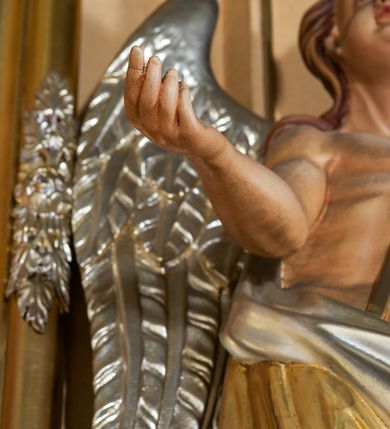 Zdjęcie nr 12: Ołtarz przyścienny, architektoniczny, jednoosiowy, jednokondygnacyjny ze zwieńczeniem. Mensa prostopadłościenna na profilowanym cokole, antepedium dekorowane trzema płycinami z plakietami z ornamentu roślinnego. Tabernakulum architektoniczne, w formie prostopadłościanu na profilowanym cokole, o ujętym wolutami wklęsło-wypukłym zwieńczeniu. Na ścianie frontowej drzwiczki w kształcie stojącego prostokąta zamkniętego łukiem nadwieszonym z uskokiem. Nastawa ołtarzowa ujęta  pilastrami z płycinami ustawionymi na wysokich cokołach, na których wspierają się konsole podtrzymujące rzeźby aniołów. Podpory dźwigają pełne, wyłamane na ich osiach belkowanie, na którym posadowiono figury aniołków. W centrum kondygnacji prostokątna nisza mieszcząca obraz „Męczeństwo św. Bartłomieja”, ujęta prostokątną ramą dekorowaną w czterech miejscach kwitnącymi różami z liśćmi. Między polem obrazowym a belkowaniem kondygnacji unoszony przez dwa anioły kartusz z inskrypcją „ŚWIĘTY / BARTŁOMIEJU / MÓDL SIĘ / ZA NAMI”. Zwieńczenie o kształcie wklęsło-wypukłym, ujęte ulistnionymi wolutami, wypełnione obrazem powtarzającym jego kształt, przedstawiającym Jezusa Chrystusa. Na szczycie krzyż równoramienny o ramionach zakończonych trójlistnie, na tle glorii.  Struktura ołtarza w kolorze kremowym; profile, detale i ornamenty złocone i srebrzone.