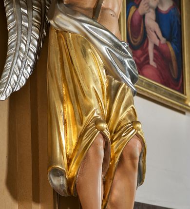 Zdjęcie nr 11: Ołtarz przyścienny, architektoniczny, jednoosiowy, jednokondygnacyjny ze zwieńczeniem. Mensa prostopadłościenna na profilowanym cokole, antepedium dekorowane trzema płycinami z plakietami z ornamentu roślinnego. Tabernakulum architektoniczne, w formie prostopadłościanu na profilowanym cokole, o ujętym wolutami wklęsło-wypukłym zwieńczeniu. Na ścianie frontowej drzwiczki w kształcie stojącego prostokąta zamkniętego łukiem nadwieszonym z uskokiem. Nastawa ołtarzowa ujęta  pilastrami z płycinami ustawionymi na wysokich cokołach, na których wspierają się konsole podtrzymujące rzeźby aniołów. Podpory dźwigają pełne, wyłamane na ich osiach belkowanie, na którym posadowiono figury aniołków. W centrum kondygnacji prostokątna nisza mieszcząca obraz „Męczeństwo św. Bartłomieja”, ujęta prostokątną ramą dekorowaną w czterech miejscach kwitnącymi różami z liśćmi. Między polem obrazowym a belkowaniem kondygnacji unoszony przez dwa anioły kartusz z inskrypcją „ŚWIĘTY / BARTŁOMIEJU / MÓDL SIĘ / ZA NAMI”. Zwieńczenie o kształcie wklęsło-wypukłym, ujęte ulistnionymi wolutami, wypełnione obrazem powtarzającym jego kształt, przedstawiającym Jezusa Chrystusa. Na szczycie krzyż równoramienny o ramionach zakończonych trójlistnie, na tle glorii.  Struktura ołtarza w kolorze kremowym; profile, detale i ornamenty złocone i srebrzone.