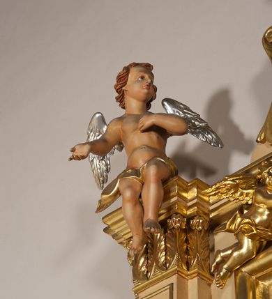 Zdjęcie nr 21: Ołtarz przyścienny, architektoniczny, jednoosiowy, jednokondygnacyjny ze zwieńczeniem. Mensa prostopadłościenna na profilowanym cokole, antepedium dekorowane trzema płycinami z plakietami z ornamentu roślinnego. Tabernakulum architektoniczne, w formie prostopadłościanu na profilowanym cokole, o ujętym wolutami wklęsło-wypukłym zwieńczeniu. Na ścianie frontowej drzwiczki w kształcie stojącego prostokąta zamkniętego łukiem nadwieszonym z uskokiem. Nastawa ołtarzowa ujęta  pilastrami z płycinami ustawionymi na wysokich cokołach, na których wspierają się konsole podtrzymujące rzeźby aniołów. Podpory dźwigają pełne, wyłamane na ich osiach belkowanie, na którym posadowiono figury aniołków. W centrum kondygnacji prostokątna nisza mieszcząca obraz „Męczeństwo św. Bartłomieja”, ujęta prostokątną ramą dekorowaną w czterech miejscach kwitnącymi różami z liśćmi. Między polem obrazowym a belkowaniem kondygnacji unoszony przez dwa anioły kartusz z inskrypcją „ŚWIĘTY / BARTŁOMIEJU / MÓDL SIĘ / ZA NAMI”. Zwieńczenie o kształcie wklęsło-wypukłym, ujęte ulistnionymi wolutami, wypełnione obrazem powtarzającym jego kształt, przedstawiającym Jezusa Chrystusa. Na szczycie krzyż równoramienny o ramionach zakończonych trójlistnie, na tle glorii.  Struktura ołtarza w kolorze kremowym; profile, detale i ornamenty złocone i srebrzone.