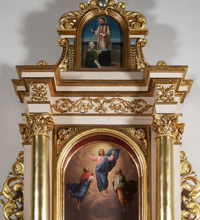 Zdjęcie nr 9: Ołtarz przyścienny, architektoniczny, jednoosiowy, jednokondygnacyjny ze zwieńczeniem, z uszakami. Mensa prostopadłościenna na cokole; antepedium dekorowane trzema płycinami, z których środkowa wypełniona emblematem franciszkańskim złożonym ze skrzyżowanych rąk poniżej krzyża w glorii. Tabernakulum architektoniczne, o ściętych narożach podkreślonych lizenami, na profilowanym cokole. W ścianie frontowej nisza w kształcie stojącego prostokąta zamkniętego łukiem pełnym z umocowanymi na czerwonym tle relikwiami. Kondygnację zamyka gzyms i uskokowe zwieńczenie pełniące funkcję podstawy pod krucyfiks. Nastawa ołtarzowa, ujęta kompozytowymi kolumnami ustawionymi na wysokich postumentach zdobionych plakietami roślinnymi. Dźwigają one pełne, wyłamane na ich osiach belkowanie . Fryz wysuniętych części dekorowany rozetami, a cofniętej fragmentem symetrycznej wici. W centrum kondygnacji nisza zamknięta łukiem półkolistym mieszcząca obraz „Przemienienie Pańskie” i wizerunek św. Franciszka na zasuwie. Nisza ujęta prostokątną ramą, której wolne naroża wypełniają uskrzydlone główki anielskie. Kondygnacja ujęta ażurowymi uszakami z wici roślinnej. W zwieńczeniu przedstawienie św. Walentego w formie stojącego prostokąta zamkniętego łukiem pełnym, ujęte pilastrami z cekinami i wolutami podtrzymującymi fragmenty belkowania. Od góry nisza ujęta rzeźbionym, ornamentalnym zwieńczeniem o wklęsło-wypukłym profilu złożonym z ulistnionych wolut ujmujących kartusz z owalnym polem podtrzymujący woluty tworzące kształt serca. 
Struktura ołtarza w kolorze białym; profile, detale, ornamenty i kolumny złocone.
