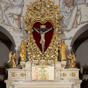 Zdjęcie nr 1: Ołtarz w formie rzeźbionej, ażurowej ramy na trójstopniowym cokole, z prostopadłościenną mensą z antepedium dekorowanym kwadratowymi płycinami z motywem czworoliścia. Na nim prostopadłościenne tabernakulum z drzwiami w kształcie stojącego prostokąta dekorowanymi koszem z chlebem, rybami i chrystogramem. Środkowa część podstawy wypełniona płycinami w kształcie leżących prostokątów z plakietami roślinnymi. Na jej zewnętrznych częściach posadowiono figury klęczących aniołów. Najwyższy stopień węższy, trójosiowy, o osiach zewnętrznych wysuniętych, flankowany konsolami z rzeźbami Matki Boskiej po lewej stronie i św. Jana Ewangelisty po prawej. Centralnie umieszczona rama ujmuje pole w kształcie serca, na tle którego jest eksponowany krucyfiks. Ażur tworzy wić winnej latorośli z kiśćmi winogron, a w nią wkomponowane jest siedem postaci aniołów trzymających banderole z ostatnimi słowami wypowiedzianymi przez Chrystusa wiszącego na krzyżu. Od góry: „Pragnę”, „Niewiasto! Oto syn Twój”, „Oto matka twoja”, „Ojcze odpuść im, / bo nie wiedzą co czynią”, „Zaprawdę powiadam tobie / dziś jeszcze będziesz ze Mną w raju”, „Spełniło się! / Ojcze w ręce Twoje oddaję ducha mojego”, „Boże mój Boże mój / czemużeś mnie opuścił”. Struktura w kolorze kremowym, profile, detale i ornamenty złocone; banderole srebrzone. 