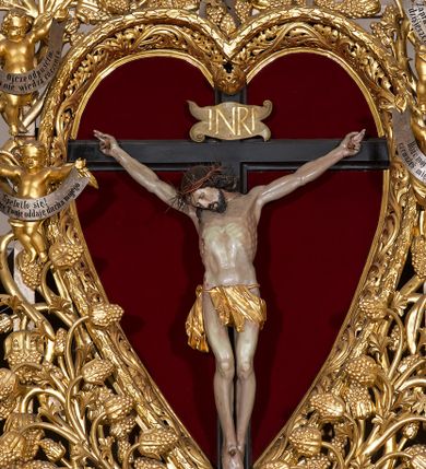 Zdjęcie nr 3: Ołtarz w formie rzeźbionej, ażurowej ramy na trójstopniowym cokole, z prostopadłościenną mensą z antepedium dekorowanym kwadratowymi płycinami z motywem czworoliścia. Na nim prostopadłościenne tabernakulum z drzwiami w kształcie stojącego prostokąta dekorowanymi koszem z chlebem, rybami i chrystogramem. Środkowa część podstawy wypełniona płycinami w kształcie leżących prostokątów z plakietami roślinnymi. Na jej zewnętrznych częściach posadowiono figury klęczących aniołów. Najwyższy stopień węższy, trójosiowy, o osiach zewnętrznych wysuniętych, flankowany konsolami z rzeźbami Matki Boskiej po lewej stronie i św. Jana Ewangelisty po prawej. Centralnie umieszczona rama ujmuje pole w kształcie serca, na tle którego jest eksponowany krucyfiks. Ażur tworzy wić winnej latorośli z kiśćmi winogron, a w nią wkomponowane jest siedem postaci aniołów trzymających banderole z ostatnimi słowami wypowiedzianymi przez Chrystusa wiszącego na krzyżu. Od góry: „Pragnę”, „Niewiasto! Oto syn Twój”, „Oto matka twoja”, „Ojcze odpuść im, / bo nie wiedzą co czynią”, „Zaprawdę powiadam tobie / dziś jeszcze będziesz ze Mną w raju”, „Spełniło się! / Ojcze w ręce Twoje oddaję ducha mojego”, „Boże mój Boże mój / czemużeś mnie opuścił”. Struktura w kolorze kremowym, profile, detale i ornamenty złocone; banderole srebrzone. 