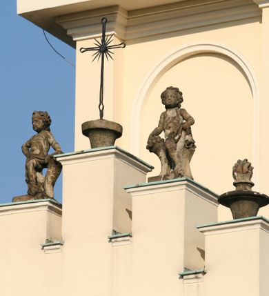 Zdjęcie nr 155: Kościół murowany, orientowany, jednonawowy, z transeptem, prezbiterium z obejściem i przybudówkami. Od zachodu kruchta, od północy kwadratowa kaplica, od południa kolejna przybudówka. 
Prezbiterium zamknięte półokrągło, z obejściem przeprutym do niego arkadami wspartymi na filarach. Ściany nawy i prezbiterium gładkie, przekryte sklepieniem kolebkowym z lunetami, w których mieszczą się okna. Transept i przecięcie naw sklepione krzyżowo. Na ścianach polichromia figuralna ze scenami z Nowego Testamentu, w partii sklepienia drobne, złote gwiazdki. Od zachodu chór zatopiony w występującym asymetrycznie murze, z tralkową balustradą. W prezbiterium siedem okien w kształcie stojącego prostokąta zamkniętego łukiem pełnym wypełnionych witrażami, w nawie sześć okien, w ramionach transeptu po jednym, czterodzielnym, wypełnionym witrażem, na wysokości chóru po dwa z każdej strony. Główne wejście od zachodu przez kruchtę. Fasada poprzedzona przedsionkiem o podziałach ramowych, z prostokątnym wejściem na osi, flankowanym parą pilastrów i prostokątnymi płycinami. Kondygnację wieńczy pełne belkowanie z wysuniętym gzymsem podtrzymującym daszek i trójkątny, schodkowy szczyt zakończony postumentami. Na centralnym krzyż, na sąsiadujących figury dzieci z rogami obfitości, a na zewnętrznych wazony płomieniste; szczyt ujmują postumenty z kulami. Fasada dwukondygnacyjna ze szczytem. Kondygnacja trójosiowa, rozdzielona pilastrami, o polach wypełnionych blendami w kształcie stojących prostokątów zamkniętych łukiem pełnym; szczyt trójkątny, z tarczą zegarową pośrodku. Budynek kościoła o wyraźnych podziałach na bryły składowe, ściany gładkie, przeprute oknami, z gzymsami pod krawędziami dachu. 
Nad nawą główną, na kalenicy, wieżyczka na sygnaturkę z latarnią i baniastym hełmem, druga na skrzyżowaniu naw, z latarnią i  hełmem zakończonym krzyżem. Dach nad nawą główną i przedsionkiem dwuspadowy, nad ramionami transeptu trójspadowym,nad prezbiterium zakończony wielobocznie, na przybudówkach dachy pulpitowe, dwuspadowe i wielospadowe. Dachy kryte dachówką ceramiczną, wieżyczki blachą. 
Najciekawszymi zabytkami kościoła są ołtarz główny z około 1700 roku z nastawą utworzoną z wici winnej latorośli, manierystyczny ołtarz boczny oraz siedemnastowieczna chrzcielnica z warsztatu Santi Gucciego. 
