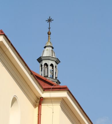 Zdjęcie nr 159: Kościół murowany, orientowany, jednonawowy, z transeptem, prezbiterium z obejściem i przybudówkami. Od zachodu kruchta, od północy kwadratowa kaplica, od południa kolejna przybudówka. 
Prezbiterium zamknięte półokrągło, z obejściem przeprutym do niego arkadami wspartymi na filarach. Ściany nawy i prezbiterium gładkie, przekryte sklepieniem kolebkowym z lunetami, w których mieszczą się okna. Transept i przecięcie naw sklepione krzyżowo. Na ścianach polichromia figuralna ze scenami z Nowego Testamentu, w partii sklepienia drobne, złote gwiazdki. Od zachodu chór zatopiony w występującym asymetrycznie murze, z tralkową balustradą. W prezbiterium siedem okien w kształcie stojącego prostokąta zamkniętego łukiem pełnym wypełnionych witrażami, w nawie sześć okien, w ramionach transeptu po jednym, czterodzielnym, wypełnionym witrażem, na wysokości chóru po dwa z każdej strony. Główne wejście od zachodu przez kruchtę. Fasada poprzedzona przedsionkiem o podziałach ramowych, z prostokątnym wejściem na osi, flankowanym parą pilastrów i prostokątnymi płycinami. Kondygnację wieńczy pełne belkowanie z wysuniętym gzymsem podtrzymującym daszek i trójkątny, schodkowy szczyt zakończony postumentami. Na centralnym krzyż, na sąsiadujących figury dzieci z rogami obfitości, a na zewnętrznych wazony płomieniste; szczyt ujmują postumenty z kulami. Fasada dwukondygnacyjna ze szczytem. Kondygnacja trójosiowa, rozdzielona pilastrami, o polach wypełnionych blendami w kształcie stojących prostokątów zamkniętych łukiem pełnym; szczyt trójkątny, z tarczą zegarową pośrodku. Budynek kościoła o wyraźnych podziałach na bryły składowe, ściany gładkie, przeprute oknami, z gzymsami pod krawędziami dachu. 
Nad nawą główną, na kalenicy, wieżyczka na sygnaturkę z latarnią i baniastym hełmem, druga na skrzyżowaniu naw, z latarnią i  hełmem zakończonym krzyżem. Dach nad nawą główną i przedsionkiem dwuspadowy, nad ramionami transeptu trójspadowym,nad prezbiterium zakończony wielobocznie, na przybudówkach dachy pulpitowe, dwuspadowe i wielospadowe. Dachy kryte dachówką ceramiczną, wieżyczki blachą. 
Najciekawszymi zabytkami kościoła są ołtarz główny z około 1700 roku z nastawą utworzoną z wici winnej latorośli, manierystyczny ołtarz boczny oraz siedemnastowieczna chrzcielnica z warsztatu Santi Gucciego. 
