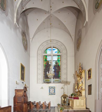 Zdjęcie nr 146: Kościół murowany, orientowany, jednonawowy, z transeptem, prezbiterium z obejściem i przybudówkami. Od zachodu kruchta, od północy kwadratowa kaplica, od południa kolejna przybudówka. 
Prezbiterium zamknięte półokrągło, z obejściem przeprutym do niego arkadami wspartymi na filarach. Ściany nawy i prezbiterium gładkie, przekryte sklepieniem kolebkowym z lunetami, w których mieszczą się okna. Transept i przecięcie naw sklepione krzyżowo. Na ścianach polichromia figuralna ze scenami z Nowego Testamentu, w partii sklepienia drobne, złote gwiazdki. Od zachodu chór zatopiony w występującym asymetrycznie murze, z tralkową balustradą. W prezbiterium siedem okien w kształcie stojącego prostokąta zamkniętego łukiem pełnym wypełnionych witrażami, w nawie sześć okien, w ramionach transeptu po jednym, czterodzielnym, wypełnionym witrażem, na wysokości chóru po dwa z każdej strony. Główne wejście od zachodu przez kruchtę. Fasada poprzedzona przedsionkiem o podziałach ramowych, z prostokątnym wejściem na osi, flankowanym parą pilastrów i prostokątnymi płycinami. Kondygnację wieńczy pełne belkowanie z wysuniętym gzymsem podtrzymującym daszek i trójkątny, schodkowy szczyt zakończony postumentami. Na centralnym krzyż, na sąsiadujących figury dzieci z rogami obfitości, a na zewnętrznych wazony płomieniste; szczyt ujmują postumenty z kulami. Fasada dwukondygnacyjna ze szczytem. Kondygnacja trójosiowa, rozdzielona pilastrami, o polach wypełnionych blendami w kształcie stojących prostokątów zamkniętych łukiem pełnym; szczyt trójkątny, z tarczą zegarową pośrodku. Budynek kościoła o wyraźnych podziałach na bryły składowe, ściany gładkie, przeprute oknami, z gzymsami pod krawędziami dachu. 
Nad nawą główną, na kalenicy, wieżyczka na sygnaturkę z latarnią i baniastym hełmem, druga na skrzyżowaniu naw, z latarnią i  hełmem zakończonym krzyżem. Dach nad nawą główną i przedsionkiem dwuspadowy, nad ramionami transeptu trójspadowym,nad prezbiterium zakończony wielobocznie, na przybudówkach dachy pulpitowe, dwuspadowe i wielospadowe. Dachy kryte dachówką ceramiczną, wieżyczki blachą. 
Najciekawszymi zabytkami kościoła są ołtarz główny z około 1700 roku z nastawą utworzoną z wici winnej latorośli, manierystyczny ołtarz boczny oraz siedemnastowieczna chrzcielnica z warsztatu Santi Gucciego. 
