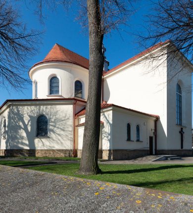 Zdjęcie nr 23: Kościół murowany, orientowany, jednonawowy, z transeptem, prezbiterium z obejściem i przybudówkami. Od zachodu kruchta, od północy kwadratowa kaplica, od południa kolejna przybudówka. 
Prezbiterium zamknięte półokrągło, z obejściem przeprutym do niego arkadami wspartymi na filarach. Ściany nawy i prezbiterium gładkie, przekryte sklepieniem kolebkowym z lunetami, w których mieszczą się okna. Transept i przecięcie naw sklepione krzyżowo. Na ścianach polichromia figuralna ze scenami z Nowego Testamentu, w partii sklepienia drobne, złote gwiazdki. Od zachodu chór zatopiony w występującym asymetrycznie murze, z tralkową balustradą. W prezbiterium siedem okien w kształcie stojącego prostokąta zamkniętego łukiem pełnym wypełnionych witrażami, w nawie sześć okien, w ramionach transeptu po jednym, czterodzielnym, wypełnionym witrażem, na wysokości chóru po dwa z każdej strony. Główne wejście od zachodu przez kruchtę. Fasada poprzedzona przedsionkiem o podziałach ramowych, z prostokątnym wejściem na osi, flankowanym parą pilastrów i prostokątnymi płycinami. Kondygnację wieńczy pełne belkowanie z wysuniętym gzymsem podtrzymującym daszek i trójkątny, schodkowy szczyt zakończony postumentami. Na centralnym krzyż, na sąsiadujących figury dzieci z rogami obfitości, a na zewnętrznych wazony płomieniste; szczyt ujmują postumenty z kulami. Fasada dwukondygnacyjna ze szczytem. Kondygnacja trójosiowa, rozdzielona pilastrami, o polach wypełnionych blendami w kształcie stojących prostokątów zamkniętych łukiem pełnym; szczyt trójkątny, z tarczą zegarową pośrodku. Budynek kościoła o wyraźnych podziałach na bryły składowe, ściany gładkie, przeprute oknami, z gzymsami pod krawędziami dachu. 
Nad nawą główną, na kalenicy, wieżyczka na sygnaturkę z latarnią i baniastym hełmem, druga na skrzyżowaniu naw, z latarnią i  hełmem zakończonym krzyżem. Dach nad nawą główną i przedsionkiem dwuspadowy, nad ramionami transeptu trójspadowym,nad prezbiterium zakończony wielobocznie, na przybudówkach dachy pulpitowe, dwuspadowe i wielospadowe. Dachy kryte dachówką ceramiczną, wieżyczki blachą. 
Najciekawszymi zabytkami kościoła są ołtarz główny z około 1700 roku z nastawą utworzoną z wici winnej latorośli, manierystyczny ołtarz boczny oraz siedemnastowieczna chrzcielnica z warsztatu Santi Gucciego. 
