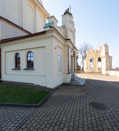 Zdjęcie nr 41: Kościół murowany, orientowany, jednonawowy, z transeptem, prezbiterium z obejściem i przybudówkami. Od zachodu kruchta, od północy kwadratowa kaplica, od południa kolejna przybudówka. 
Prezbiterium zamknięte półokrągło, z obejściem przeprutym do niego arkadami wspartymi na filarach. Ściany nawy i prezbiterium gładkie, przekryte sklepieniem kolebkowym z lunetami, w których mieszczą się okna. Transept i przecięcie naw sklepione krzyżowo. Na ścianach polichromia figuralna ze scenami z Nowego Testamentu, w partii sklepienia drobne, złote gwiazdki. Od zachodu chór zatopiony w występującym asymetrycznie murze, z tralkową balustradą. W prezbiterium siedem okien w kształcie stojącego prostokąta zamkniętego łukiem pełnym wypełnionych witrażami, w nawie sześć okien, w ramionach transeptu po jednym, czterodzielnym, wypełnionym witrażem, na wysokości chóru po dwa z każdej strony. Główne wejście od zachodu przez kruchtę. Fasada poprzedzona przedsionkiem o podziałach ramowych, z prostokątnym wejściem na osi, flankowanym parą pilastrów i prostokątnymi płycinami. Kondygnację wieńczy pełne belkowanie z wysuniętym gzymsem podtrzymującym daszek i trójkątny, schodkowy szczyt zakończony postumentami. Na centralnym krzyż, na sąsiadujących figury dzieci z rogami obfitości, a na zewnętrznych wazony płomieniste; szczyt ujmują postumenty z kulami. Fasada dwukondygnacyjna ze szczytem. Kondygnacja trójosiowa, rozdzielona pilastrami, o polach wypełnionych blendami w kształcie stojących prostokątów zamkniętych łukiem pełnym; szczyt trójkątny, z tarczą zegarową pośrodku. Budynek kościoła o wyraźnych podziałach na bryły składowe, ściany gładkie, przeprute oknami, z gzymsami pod krawędziami dachu. 
Nad nawą główną, na kalenicy, wieżyczka na sygnaturkę z latarnią i baniastym hełmem, druga na skrzyżowaniu naw, z latarnią i  hełmem zakończonym krzyżem. Dach nad nawą główną i przedsionkiem dwuspadowy, nad ramionami transeptu trójspadowym,nad prezbiterium zakończony wielobocznie, na przybudówkach dachy pulpitowe, dwuspadowe i wielospadowe. Dachy kryte dachówką ceramiczną, wieżyczki blachą. 
Najciekawszymi zabytkami kościoła są ołtarz główny z około 1700 roku z nastawą utworzoną z wici winnej latorośli, manierystyczny ołtarz boczny oraz siedemnastowieczna chrzcielnica z warsztatu Santi Gucciego. 
