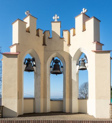 Zdjęcie nr 61: Kościół murowany, orientowany, jednonawowy, z transeptem, prezbiterium z obejściem i przybudówkami. Od zachodu kruchta, od północy kwadratowa kaplica, od południa kolejna przybudówka. 
Prezbiterium zamknięte półokrągło, z obejściem przeprutym do niego arkadami wspartymi na filarach. Ściany nawy i prezbiterium gładkie, przekryte sklepieniem kolebkowym z lunetami, w których mieszczą się okna. Transept i przecięcie naw sklepione krzyżowo. Na ścianach polichromia figuralna ze scenami z Nowego Testamentu, w partii sklepienia drobne, złote gwiazdki. Od zachodu chór zatopiony w występującym asymetrycznie murze, z tralkową balustradą. W prezbiterium siedem okien w kształcie stojącego prostokąta zamkniętego łukiem pełnym wypełnionych witrażami, w nawie sześć okien, w ramionach transeptu po jednym, czterodzielnym, wypełnionym witrażem, na wysokości chóru po dwa z każdej strony. Główne wejście od zachodu przez kruchtę. Fasada poprzedzona przedsionkiem o podziałach ramowych, z prostokątnym wejściem na osi, flankowanym parą pilastrów i prostokątnymi płycinami. Kondygnację wieńczy pełne belkowanie z wysuniętym gzymsem podtrzymującym daszek i trójkątny, schodkowy szczyt zakończony postumentami. Na centralnym krzyż, na sąsiadujących figury dzieci z rogami obfitości, a na zewnętrznych wazony płomieniste; szczyt ujmują postumenty z kulami. Fasada dwukondygnacyjna ze szczytem. Kondygnacja trójosiowa, rozdzielona pilastrami, o polach wypełnionych blendami w kształcie stojących prostokątów zamkniętych łukiem pełnym; szczyt trójkątny, z tarczą zegarową pośrodku. Budynek kościoła o wyraźnych podziałach na bryły składowe, ściany gładkie, przeprute oknami, z gzymsami pod krawędziami dachu. 
Nad nawą główną, na kalenicy, wieżyczka na sygnaturkę z latarnią i baniastym hełmem, druga na skrzyżowaniu naw, z latarnią i  hełmem zakończonym krzyżem. Dach nad nawą główną i przedsionkiem dwuspadowy, nad ramionami transeptu trójspadowym,nad prezbiterium zakończony wielobocznie, na przybudówkach dachy pulpitowe, dwuspadowe i wielospadowe. Dachy kryte dachówką ceramiczną, wieżyczki blachą. 
Najciekawszymi zabytkami kościoła są ołtarz główny z około 1700 roku z nastawą utworzoną z wici winnej latorośli, manierystyczny ołtarz boczny oraz siedemnastowieczna chrzcielnica z warsztatu Santi Gucciego. 
