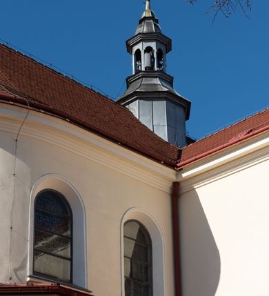 Zdjęcie nr 66: Kościół murowany, orientowany, jednonawowy, z transeptem, prezbiterium z obejściem i przybudówkami. Od zachodu kruchta, od północy kwadratowa kaplica, od południa kolejna przybudówka. 
Prezbiterium zamknięte półokrągło, z obejściem przeprutym do niego arkadami wspartymi na filarach. Ściany nawy i prezbiterium gładkie, przekryte sklepieniem kolebkowym z lunetami, w których mieszczą się okna. Transept i przecięcie naw sklepione krzyżowo. Na ścianach polichromia figuralna ze scenami z Nowego Testamentu, w partii sklepienia drobne, złote gwiazdki. Od zachodu chór zatopiony w występującym asymetrycznie murze, z tralkową balustradą. W prezbiterium siedem okien w kształcie stojącego prostokąta zamkniętego łukiem pełnym wypełnionych witrażami, w nawie sześć okien, w ramionach transeptu po jednym, czterodzielnym, wypełnionym witrażem, na wysokości chóru po dwa z każdej strony. Główne wejście od zachodu przez kruchtę. Fasada poprzedzona przedsionkiem o podziałach ramowych, z prostokątnym wejściem na osi, flankowanym parą pilastrów i prostokątnymi płycinami. Kondygnację wieńczy pełne belkowanie z wysuniętym gzymsem podtrzymującym daszek i trójkątny, schodkowy szczyt zakończony postumentami. Na centralnym krzyż, na sąsiadujących figury dzieci z rogami obfitości, a na zewnętrznych wazony płomieniste; szczyt ujmują postumenty z kulami. Fasada dwukondygnacyjna ze szczytem. Kondygnacja trójosiowa, rozdzielona pilastrami, o polach wypełnionych blendami w kształcie stojących prostokątów zamkniętych łukiem pełnym; szczyt trójkątny, z tarczą zegarową pośrodku. Budynek kościoła o wyraźnych podziałach na bryły składowe, ściany gładkie, przeprute oknami, z gzymsami pod krawędziami dachu. 
Nad nawą główną, na kalenicy, wieżyczka na sygnaturkę z latarnią i baniastym hełmem, druga na skrzyżowaniu naw, z latarnią i  hełmem zakończonym krzyżem. Dach nad nawą główną i przedsionkiem dwuspadowy, nad ramionami transeptu trójspadowym,nad prezbiterium zakończony wielobocznie, na przybudówkach dachy pulpitowe, dwuspadowe i wielospadowe. Dachy kryte dachówką ceramiczną, wieżyczki blachą. 
Najciekawszymi zabytkami kościoła są ołtarz główny z około 1700 roku z nastawą utworzoną z wici winnej latorośli, manierystyczny ołtarz boczny oraz siedemnastowieczna chrzcielnica z warsztatu Santi Gucciego. 
