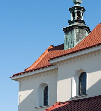 Zdjęcie nr 73: Kościół murowany, orientowany, jednonawowy, z transeptem, prezbiterium z obejściem i przybudówkami. Od zachodu kruchta, od północy kwadratowa kaplica, od południa kolejna przybudówka. 
Prezbiterium zamknięte półokrągło, z obejściem przeprutym do niego arkadami wspartymi na filarach. Ściany nawy i prezbiterium gładkie, przekryte sklepieniem kolebkowym z lunetami, w których mieszczą się okna. Transept i przecięcie naw sklepione krzyżowo. Na ścianach polichromia figuralna ze scenami z Nowego Testamentu, w partii sklepienia drobne, złote gwiazdki. Od zachodu chór zatopiony w występującym asymetrycznie murze, z tralkową balustradą. W prezbiterium siedem okien w kształcie stojącego prostokąta zamkniętego łukiem pełnym wypełnionych witrażami, w nawie sześć okien, w ramionach transeptu po jednym, czterodzielnym, wypełnionym witrażem, na wysokości chóru po dwa z każdej strony. Główne wejście od zachodu przez kruchtę. Fasada poprzedzona przedsionkiem o podziałach ramowych, z prostokątnym wejściem na osi, flankowanym parą pilastrów i prostokątnymi płycinami. Kondygnację wieńczy pełne belkowanie z wysuniętym gzymsem podtrzymującym daszek i trójkątny, schodkowy szczyt zakończony postumentami. Na centralnym krzyż, na sąsiadujących figury dzieci z rogami obfitości, a na zewnętrznych wazony płomieniste; szczyt ujmują postumenty z kulami. Fasada dwukondygnacyjna ze szczytem. Kondygnacja trójosiowa, rozdzielona pilastrami, o polach wypełnionych blendami w kształcie stojących prostokątów zamkniętych łukiem pełnym; szczyt trójkątny, z tarczą zegarową pośrodku. Budynek kościoła o wyraźnych podziałach na bryły składowe, ściany gładkie, przeprute oknami, z gzymsami pod krawędziami dachu. 
Nad nawą główną, na kalenicy, wieżyczka na sygnaturkę z latarnią i baniastym hełmem, druga na skrzyżowaniu naw, z latarnią i  hełmem zakończonym krzyżem. Dach nad nawą główną i przedsionkiem dwuspadowy, nad ramionami transeptu trójspadowym,nad prezbiterium zakończony wielobocznie, na przybudówkach dachy pulpitowe, dwuspadowe i wielospadowe. Dachy kryte dachówką ceramiczną, wieżyczki blachą. 
Najciekawszymi zabytkami kościoła są ołtarz główny z około 1700 roku z nastawą utworzoną z wici winnej latorośli, manierystyczny ołtarz boczny oraz siedemnastowieczna chrzcielnica z warsztatu Santi Gucciego. 
