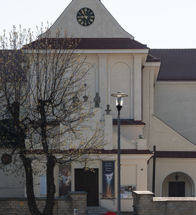 Zdjęcie nr 83: Kościół murowany, orientowany, jednonawowy, z transeptem, prezbiterium z obejściem i przybudówkami. Od zachodu kruchta, od północy kwadratowa kaplica, od południa kolejna przybudówka. 
Prezbiterium zamknięte półokrągło, z obejściem przeprutym do niego arkadami wspartymi na filarach. Ściany nawy i prezbiterium gładkie, przekryte sklepieniem kolebkowym z lunetami, w których mieszczą się okna. Transept i przecięcie naw sklepione krzyżowo. Na ścianach polichromia figuralna ze scenami z Nowego Testamentu, w partii sklepienia drobne, złote gwiazdki. Od zachodu chór zatopiony w występującym asymetrycznie murze, z tralkową balustradą. W prezbiterium siedem okien w kształcie stojącego prostokąta zamkniętego łukiem pełnym wypełnionych witrażami, w nawie sześć okien, w ramionach transeptu po jednym, czterodzielnym, wypełnionym witrażem, na wysokości chóru po dwa z każdej strony. Główne wejście od zachodu przez kruchtę. Fasada poprzedzona przedsionkiem o podziałach ramowych, z prostokątnym wejściem na osi, flankowanym parą pilastrów i prostokątnymi płycinami. Kondygnację wieńczy pełne belkowanie z wysuniętym gzymsem podtrzymującym daszek i trójkątny, schodkowy szczyt zakończony postumentami. Na centralnym krzyż, na sąsiadujących figury dzieci z rogami obfitości, a na zewnętrznych wazony płomieniste; szczyt ujmują postumenty z kulami. Fasada dwukondygnacyjna ze szczytem. Kondygnacja trójosiowa, rozdzielona pilastrami, o polach wypełnionych blendami w kształcie stojących prostokątów zamkniętych łukiem pełnym; szczyt trójkątny, z tarczą zegarową pośrodku. Budynek kościoła o wyraźnych podziałach na bryły składowe, ściany gładkie, przeprute oknami, z gzymsami pod krawędziami dachu. 
Nad nawą główną, na kalenicy, wieżyczka na sygnaturkę z latarnią i baniastym hełmem, druga na skrzyżowaniu naw, z latarnią i  hełmem zakończonym krzyżem. Dach nad nawą główną i przedsionkiem dwuspadowy, nad ramionami transeptu trójspadowym,nad prezbiterium zakończony wielobocznie, na przybudówkach dachy pulpitowe, dwuspadowe i wielospadowe. Dachy kryte dachówką ceramiczną, wieżyczki blachą. 
Najciekawszymi zabytkami kościoła są ołtarz główny z około 1700 roku z nastawą utworzoną z wici winnej latorośli, manierystyczny ołtarz boczny oraz siedemnastowieczna chrzcielnica z warsztatu Santi Gucciego. 
