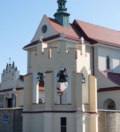 Zdjęcie nr 87: Kościół murowany, orientowany, jednonawowy, z transeptem, prezbiterium z obejściem i przybudówkami. Od zachodu kruchta, od północy kwadratowa kaplica, od południa kolejna przybudówka. 
Prezbiterium zamknięte półokrągło, z obejściem przeprutym do niego arkadami wspartymi na filarach. Ściany nawy i prezbiterium gładkie, przekryte sklepieniem kolebkowym z lunetami, w których mieszczą się okna. Transept i przecięcie naw sklepione krzyżowo. Na ścianach polichromia figuralna ze scenami z Nowego Testamentu, w partii sklepienia drobne, złote gwiazdki. Od zachodu chór zatopiony w występującym asymetrycznie murze, z tralkową balustradą. W prezbiterium siedem okien w kształcie stojącego prostokąta zamkniętego łukiem pełnym wypełnionych witrażami, w nawie sześć okien, w ramionach transeptu po jednym, czterodzielnym, wypełnionym witrażem, na wysokości chóru po dwa z każdej strony. Główne wejście od zachodu przez kruchtę. Fasada poprzedzona przedsionkiem o podziałach ramowych, z prostokątnym wejściem na osi, flankowanym parą pilastrów i prostokątnymi płycinami. Kondygnację wieńczy pełne belkowanie z wysuniętym gzymsem podtrzymującym daszek i trójkątny, schodkowy szczyt zakończony postumentami. Na centralnym krzyż, na sąsiadujących figury dzieci z rogami obfitości, a na zewnętrznych wazony płomieniste; szczyt ujmują postumenty z kulami. Fasada dwukondygnacyjna ze szczytem. Kondygnacja trójosiowa, rozdzielona pilastrami, o polach wypełnionych blendami w kształcie stojących prostokątów zamkniętych łukiem pełnym; szczyt trójkątny, z tarczą zegarową pośrodku. Budynek kościoła o wyraźnych podziałach na bryły składowe, ściany gładkie, przeprute oknami, z gzymsami pod krawędziami dachu. 
Nad nawą główną, na kalenicy, wieżyczka na sygnaturkę z latarnią i baniastym hełmem, druga na skrzyżowaniu naw, z latarnią i  hełmem zakończonym krzyżem. Dach nad nawą główną i przedsionkiem dwuspadowy, nad ramionami transeptu trójspadowym,nad prezbiterium zakończony wielobocznie, na przybudówkach dachy pulpitowe, dwuspadowe i wielospadowe. Dachy kryte dachówką ceramiczną, wieżyczki blachą. 
Najciekawszymi zabytkami kościoła są ołtarz główny z około 1700 roku z nastawą utworzoną z wici winnej latorośli, manierystyczny ołtarz boczny oraz siedemnastowieczna chrzcielnica z warsztatu Santi Gucciego. 
