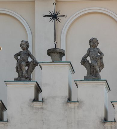 Zdjęcie nr 93: Kościół murowany, orientowany, jednonawowy, z transeptem, prezbiterium z obejściem i przybudówkami. Od zachodu kruchta, od północy kwadratowa kaplica, od południa kolejna przybudówka. 
Prezbiterium zamknięte półokrągło, z obejściem przeprutym do niego arkadami wspartymi na filarach. Ściany nawy i prezbiterium gładkie, przekryte sklepieniem kolebkowym z lunetami, w których mieszczą się okna. Transept i przecięcie naw sklepione krzyżowo. Na ścianach polichromia figuralna ze scenami z Nowego Testamentu, w partii sklepienia drobne, złote gwiazdki. Od zachodu chór zatopiony w występującym asymetrycznie murze, z tralkową balustradą. W prezbiterium siedem okien w kształcie stojącego prostokąta zamkniętego łukiem pełnym wypełnionych witrażami, w nawie sześć okien, w ramionach transeptu po jednym, czterodzielnym, wypełnionym witrażem, na wysokości chóru po dwa z każdej strony. Główne wejście od zachodu przez kruchtę. Fasada poprzedzona przedsionkiem o podziałach ramowych, z prostokątnym wejściem na osi, flankowanym parą pilastrów i prostokątnymi płycinami. Kondygnację wieńczy pełne belkowanie z wysuniętym gzymsem podtrzymującym daszek i trójkątny, schodkowy szczyt zakończony postumentami. Na centralnym krzyż, na sąsiadujących figury dzieci z rogami obfitości, a na zewnętrznych wazony płomieniste; szczyt ujmują postumenty z kulami. Fasada dwukondygnacyjna ze szczytem. Kondygnacja trójosiowa, rozdzielona pilastrami, o polach wypełnionych blendami w kształcie stojących prostokątów zamkniętych łukiem pełnym; szczyt trójkątny, z tarczą zegarową pośrodku. Budynek kościoła o wyraźnych podziałach na bryły składowe, ściany gładkie, przeprute oknami, z gzymsami pod krawędziami dachu. 
Nad nawą główną, na kalenicy, wieżyczka na sygnaturkę z latarnią i baniastym hełmem, druga na skrzyżowaniu naw, z latarnią i  hełmem zakończonym krzyżem. Dach nad nawą główną i przedsionkiem dwuspadowy, nad ramionami transeptu trójspadowym,nad prezbiterium zakończony wielobocznie, na przybudówkach dachy pulpitowe, dwuspadowe i wielospadowe. Dachy kryte dachówką ceramiczną, wieżyczki blachą. 
Najciekawszymi zabytkami kościoła są ołtarz główny z około 1700 roku z nastawą utworzoną z wici winnej latorośli, manierystyczny ołtarz boczny oraz siedemnastowieczna chrzcielnica z warsztatu Santi Gucciego. 
