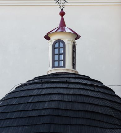 Zdjęcie nr 98: Kościół murowany, orientowany, jednonawowy, z transeptem, prezbiterium z obejściem i przybudówkami. Od zachodu kruchta, od północy kwadratowa kaplica, od południa kolejna przybudówka. 
Prezbiterium zamknięte półokrągło, z obejściem przeprutym do niego arkadami wspartymi na filarach. Ściany nawy i prezbiterium gładkie, przekryte sklepieniem kolebkowym z lunetami, w których mieszczą się okna. Transept i przecięcie naw sklepione krzyżowo. Na ścianach polichromia figuralna ze scenami z Nowego Testamentu, w partii sklepienia drobne, złote gwiazdki. Od zachodu chór zatopiony w występującym asymetrycznie murze, z tralkową balustradą. W prezbiterium siedem okien w kształcie stojącego prostokąta zamkniętego łukiem pełnym wypełnionych witrażami, w nawie sześć okien, w ramionach transeptu po jednym, czterodzielnym, wypełnionym witrażem, na wysokości chóru po dwa z każdej strony. Główne wejście od zachodu przez kruchtę. Fasada poprzedzona przedsionkiem o podziałach ramowych, z prostokątnym wejściem na osi, flankowanym parą pilastrów i prostokątnymi płycinami. Kondygnację wieńczy pełne belkowanie z wysuniętym gzymsem podtrzymującym daszek i trójkątny, schodkowy szczyt zakończony postumentami. Na centralnym krzyż, na sąsiadujących figury dzieci z rogami obfitości, a na zewnętrznych wazony płomieniste; szczyt ujmują postumenty z kulami. Fasada dwukondygnacyjna ze szczytem. Kondygnacja trójosiowa, rozdzielona pilastrami, o polach wypełnionych blendami w kształcie stojących prostokątów zamkniętych łukiem pełnym; szczyt trójkątny, z tarczą zegarową pośrodku. Budynek kościoła o wyraźnych podziałach na bryły składowe, ściany gładkie, przeprute oknami, z gzymsami pod krawędziami dachu. 
Nad nawą główną, na kalenicy, wieżyczka na sygnaturkę z latarnią i baniastym hełmem, druga na skrzyżowaniu naw, z latarnią i  hełmem zakończonym krzyżem. Dach nad nawą główną i przedsionkiem dwuspadowy, nad ramionami transeptu trójspadowym,nad prezbiterium zakończony wielobocznie, na przybudówkach dachy pulpitowe, dwuspadowe i wielospadowe. Dachy kryte dachówką ceramiczną, wieżyczki blachą. 
Najciekawszymi zabytkami kościoła są ołtarz główny z około 1700 roku z nastawą utworzoną z wici winnej latorośli, manierystyczny ołtarz boczny oraz siedemnastowieczna chrzcielnica z warsztatu Santi Gucciego. 
