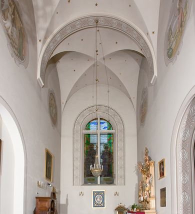 Zdjęcie nr 123: Kościół murowany, orientowany, jednonawowy, z transeptem, prezbiterium z obejściem i przybudówkami. Od zachodu kruchta, od północy kwadratowa kaplica, od południa kolejna przybudówka. 
Prezbiterium zamknięte półokrągło, z obejściem przeprutym do niego arkadami wspartymi na filarach. Ściany nawy i prezbiterium gładkie, przekryte sklepieniem kolebkowym z lunetami, w których mieszczą się okna. Transept i przecięcie naw sklepione krzyżowo. Na ścianach polichromia figuralna ze scenami z Nowego Testamentu, w partii sklepienia drobne, złote gwiazdki. Od zachodu chór zatopiony w występującym asymetrycznie murze, z tralkową balustradą. W prezbiterium siedem okien w kształcie stojącego prostokąta zamkniętego łukiem pełnym wypełnionych witrażami, w nawie sześć okien, w ramionach transeptu po jednym, czterodzielnym, wypełnionym witrażem, na wysokości chóru po dwa z każdej strony. Główne wejście od zachodu przez kruchtę. Fasada poprzedzona przedsionkiem o podziałach ramowych, z prostokątnym wejściem na osi, flankowanym parą pilastrów i prostokątnymi płycinami. Kondygnację wieńczy pełne belkowanie z wysuniętym gzymsem podtrzymującym daszek i trójkątny, schodkowy szczyt zakończony postumentami. Na centralnym krzyż, na sąsiadujących figury dzieci z rogami obfitości, a na zewnętrznych wazony płomieniste; szczyt ujmują postumenty z kulami. Fasada dwukondygnacyjna ze szczytem. Kondygnacja trójosiowa, rozdzielona pilastrami, o polach wypełnionych blendami w kształcie stojących prostokątów zamkniętych łukiem pełnym; szczyt trójkątny, z tarczą zegarową pośrodku. Budynek kościoła o wyraźnych podziałach na bryły składowe, ściany gładkie, przeprute oknami, z gzymsami pod krawędziami dachu. 
Nad nawą główną, na kalenicy, wieżyczka na sygnaturkę z latarnią i baniastym hełmem, druga na skrzyżowaniu naw, z latarnią i  hełmem zakończonym krzyżem. Dach nad nawą główną i przedsionkiem dwuspadowy, nad ramionami transeptu trójspadowym,nad prezbiterium zakończony wielobocznie, na przybudówkach dachy pulpitowe, dwuspadowe i wielospadowe. Dachy kryte dachówką ceramiczną, wieżyczki blachą. 
Najciekawszymi zabytkami kościoła są ołtarz główny z około 1700 roku z nastawą utworzoną z wici winnej latorośli, manierystyczny ołtarz boczny oraz siedemnastowieczna chrzcielnica z warsztatu Santi Gucciego. 
