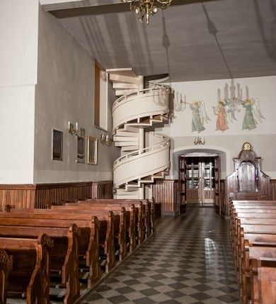 Zdjęcie nr 128: Kościół murowany, orientowany, jednonawowy, z transeptem, prezbiterium z obejściem i przybudówkami. Od zachodu kruchta, od północy kwadratowa kaplica, od południa kolejna przybudówka. 
Prezbiterium zamknięte półokrągło, z obejściem przeprutym do niego arkadami wspartymi na filarach. Ściany nawy i prezbiterium gładkie, przekryte sklepieniem kolebkowym z lunetami, w których mieszczą się okna. Transept i przecięcie naw sklepione krzyżowo. Na ścianach polichromia figuralna ze scenami z Nowego Testamentu, w partii sklepienia drobne, złote gwiazdki. Od zachodu chór zatopiony w występującym asymetrycznie murze, z tralkową balustradą. W prezbiterium siedem okien w kształcie stojącego prostokąta zamkniętego łukiem pełnym wypełnionych witrażami, w nawie sześć okien, w ramionach transeptu po jednym, czterodzielnym, wypełnionym witrażem, na wysokości chóru po dwa z każdej strony. Główne wejście od zachodu przez kruchtę. Fasada poprzedzona przedsionkiem o podziałach ramowych, z prostokątnym wejściem na osi, flankowanym parą pilastrów i prostokątnymi płycinami. Kondygnację wieńczy pełne belkowanie z wysuniętym gzymsem podtrzymującym daszek i trójkątny, schodkowy szczyt zakończony postumentami. Na centralnym krzyż, na sąsiadujących figury dzieci z rogami obfitości, a na zewnętrznych wazony płomieniste; szczyt ujmują postumenty z kulami. Fasada dwukondygnacyjna ze szczytem. Kondygnacja trójosiowa, rozdzielona pilastrami, o polach wypełnionych blendami w kształcie stojących prostokątów zamkniętych łukiem pełnym; szczyt trójkątny, z tarczą zegarową pośrodku. Budynek kościoła o wyraźnych podziałach na bryły składowe, ściany gładkie, przeprute oknami, z gzymsami pod krawędziami dachu. 
Nad nawą główną, na kalenicy, wieżyczka na sygnaturkę z latarnią i baniastym hełmem, druga na skrzyżowaniu naw, z latarnią i  hełmem zakończonym krzyżem. Dach nad nawą główną i przedsionkiem dwuspadowy, nad ramionami transeptu trójspadowym,nad prezbiterium zakończony wielobocznie, na przybudówkach dachy pulpitowe, dwuspadowe i wielospadowe. Dachy kryte dachówką ceramiczną, wieżyczki blachą. 
Najciekawszymi zabytkami kościoła są ołtarz główny z około 1700 roku z nastawą utworzoną z wici winnej latorośli, manierystyczny ołtarz boczny oraz siedemnastowieczna chrzcielnica z warsztatu Santi Gucciego. 
