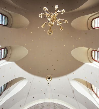 Zdjęcie nr 136: Kościół murowany, orientowany, jednonawowy, z transeptem, prezbiterium z obejściem i przybudówkami. Od zachodu kruchta, od północy kwadratowa kaplica, od południa kolejna przybudówka. 
Prezbiterium zamknięte półokrągło, z obejściem przeprutym do niego arkadami wspartymi na filarach. Ściany nawy i prezbiterium gładkie, przekryte sklepieniem kolebkowym z lunetami, w których mieszczą się okna. Transept i przecięcie naw sklepione krzyżowo. Na ścianach polichromia figuralna ze scenami z Nowego Testamentu, w partii sklepienia drobne, złote gwiazdki. Od zachodu chór zatopiony w występującym asymetrycznie murze, z tralkową balustradą. W prezbiterium siedem okien w kształcie stojącego prostokąta zamkniętego łukiem pełnym wypełnionych witrażami, w nawie sześć okien, w ramionach transeptu po jednym, czterodzielnym, wypełnionym witrażem, na wysokości chóru po dwa z każdej strony. Główne wejście od zachodu przez kruchtę. Fasada poprzedzona przedsionkiem o podziałach ramowych, z prostokątnym wejściem na osi, flankowanym parą pilastrów i prostokątnymi płycinami. Kondygnację wieńczy pełne belkowanie z wysuniętym gzymsem podtrzymującym daszek i trójkątny, schodkowy szczyt zakończony postumentami. Na centralnym krzyż, na sąsiadujących figury dzieci z rogami obfitości, a na zewnętrznych wazony płomieniste; szczyt ujmują postumenty z kulami. Fasada dwukondygnacyjna ze szczytem. Kondygnacja trójosiowa, rozdzielona pilastrami, o polach wypełnionych blendami w kształcie stojących prostokątów zamkniętych łukiem pełnym; szczyt trójkątny, z tarczą zegarową pośrodku. Budynek kościoła o wyraźnych podziałach na bryły składowe, ściany gładkie, przeprute oknami, z gzymsami pod krawędziami dachu. 
Nad nawą główną, na kalenicy, wieżyczka na sygnaturkę z latarnią i baniastym hełmem, druga na skrzyżowaniu naw, z latarnią i  hełmem zakończonym krzyżem. Dach nad nawą główną i przedsionkiem dwuspadowy, nad ramionami transeptu trójspadowym,nad prezbiterium zakończony wielobocznie, na przybudówkach dachy pulpitowe, dwuspadowe i wielospadowe. Dachy kryte dachówką ceramiczną, wieżyczki blachą. 
Najciekawszymi zabytkami kościoła są ołtarz główny z około 1700 roku z nastawą utworzoną z wici winnej latorośli, manierystyczny ołtarz boczny oraz siedemnastowieczna chrzcielnica z warsztatu Santi Gucciego. 
