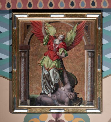 Zdjęcie nr 1: Obraz w kształcie stojącego prostokąta, zbliżonego do kwadratu, przedstawiający św. Michała Archanioła. Kompozycja flankowana malowaną, półkolistą arkadą wspartą na marmoryzowanych kolumienkach. W centrum znajduje się św. Michał Archanioł, którego skrzydła wychodzą na łuk arkady. Archanioł ukazany jest w postawie stojącej, dynamicznej. Nogami depcze szatana, a w dłoniach trzyma włócznię skierowaną ostrzem w dół, zakończoną u góry krzyżem. Twarz archanioła o delikatnych rysach z długim i prostym nosem i wzrokiem skierowanym w dół, silnie zarumienionych policzkach. Włosy średniej długości, kręcone, rozwiane do tyłu. Archanioł ubrany jest w długą i białą suknię, zieloną tunikę z szerokimi ramionami oraz krótką, czerwoną szatę wierzchnią z białym kołnierzem. Archanioł ma również parę dwukolorowych skrzydeł zielono-czerwonych, a wokół głowy ma złoty i kolisty nimb z wpisanym w polu krzyżykiem. Dół kompozycji zajmuje zielone podłoże, na którym leży nagi szatan z podkulonymi nogami, ukazany w monstrualnej postaci z ciemnymi skrzydłami u pleców. Lewą ręką ugiętą w łokciu wspiera się na podłożu, a prawą uniesioną u góry mocuje się ze św. Michałem. Tło grawerowane w symetryczny ornament roślinny. Rama obrazu profilowana, dekorowana pozłacaną i grawerowaną grubą plecionką oraz naprzemiennie posrebrzanymi wydłużonymi rautami.