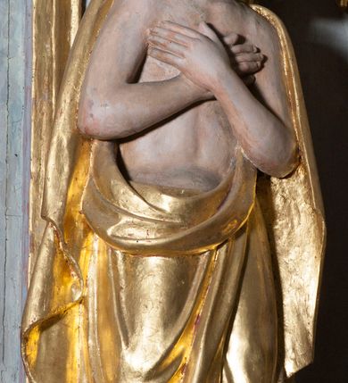 Zdjęcie nr 7: Grupa rzeźbiarska przedstawiająca scenę Chrztu Chrystusa. Rzeźby pełne, całopostaciowe. Po prawej stronie, na blikach skalnych św. Jan Chrzciciel zwrócony w prawo, z prawą nogą ustawioną wyżej, z uniesioną prawą ręką, w której trzyma muszlę z wodą, którą wylewa nad głową Chrystusa. Twarz ma pociągłą, szczupłą, okoloną krótką brodą, włosy półdługie, opadające na kark. Ubrany w osłaniający biodra płaszcz ze skóry, podtrzymywany przez taśmę przewiązaną przez lewe ramię. Po przeciwnej stronie figura Chrystusa zwróconego w trzech czwartych w lewo, w kontrapoście, delikatnie pochylonego z dłońmi skrzyżowanymi na piersi. Twarz pociągła, okolona krótką brodą, włosy długie, opadające na plecy. Na ramiona ma zarzucony płaszcz, biodra przepasane drapowaną tkaniną sięgającą kostek, tors nagi. W tle dużej wielkości gołębica Ducha Świętego na tle glorii promienistej. W odsłoniętych partiach ciała polichromia naturalistyczna, szaty złocone. 