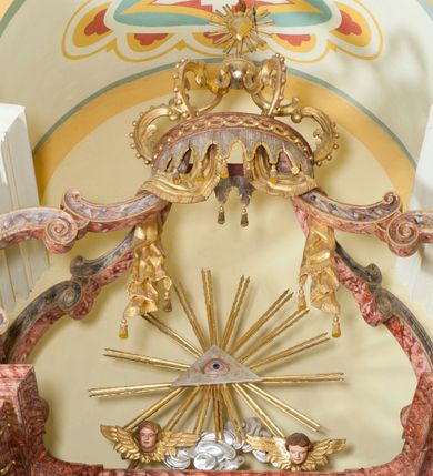 Zdjęcie nr 7: Nastawa ołtarzowa wklęsła, przyjmująca kształt wnęki; jednoosiowa, jednokondygnacyjna ze zwieńczeniem, na podwójnym cokole. Mensa sarkofagowa, wklęsło-wypukła, zwężająca się ku dołowi, ustawiona na dwóch stopniach. Drewniana z marmurowym portatylem z napisem na odwrocie „Anno Domini MDCCCXCIX Die 1. Augusti / Celsissimus ac Reverendissimus Dominus / JOANNES KNIAŹ DE KOZIELSKO / PUZYNA / Princeps Episcopus Cracoviensis altare hoc portatile / consecravit Reliquiasque SS. Cordulae et Rogatae Mill inclusit / Th. Bukowski / Vice custos […]”. Na mensie ustawiono tron wystawienia w formie sześcianu o wypukłej ścianie frontowej, ujęty pilastrami o trzonach w formie wolut, posadowionymi na cokołach. Podpory dźwigają gzyms, wyłamany pośrodku na kształt łuku odcinkowego. Wnęka obrotowa, ujęta ramą w formie wałka, flankowana płaskorzeźbionymi kłosami zbóż; we wnęce ikona Matki Boskiej Nieustającej Pomocy. Całość zwieńczona profilowanym cokołem z przedstawieniem rzeźbionego, leżącego na księdze z pieczęciami Baranka Eucharystycznego w glorii. Pierwsza kondygnacja nastawy ujęta jest ukazanymi na tle pilastrów dwiema parami kompozytowych kolumn, ustawionych w jednej linii; wewnętrzna para pod kątem. Podpory dźwigają pełne belkowanie, delikatnie wyłamane na ich osiach. W polu środkowym obraz z przedstawieniem św. Józefa, w profilowanej ramie w formie stojącego prostokąta; flankowany przez ustawione na niewielkich konsolkach figury św. Cyryla i św. Metodego. Na gzymsie płaskorzeźbione Oko Opatrzności w glorii promienistej, z obłokiem i parą uskrzydlonych główek anielskich. Zwieńczenie w formie czterech kabłąków podtrzymujących diadem zdobiony lambrekinem, ze spływającą po bokach draperią; powyżej cztery kabłąki z gorejącym sercem pośrodku. Cokoły zdobione płycinami z motywem rozet; w jednej trzeciej wysokości trzonów kolumn pierścienie. W przyłuczach ornament roślinny. Fryz zdobiony rozetami. Struktura marmoryzowana, w odcieniach jasnego różu i szarości; ornamentyka i detale złocone i srebrzone.