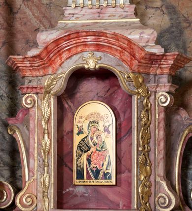 Zdjęcie nr 6: Nastawa ołtarzowa wklęsła, przyjmująca kształt wnęki; jednoosiowa, jednokondygnacyjna ze zwieńczeniem, na podwójnym cokole. Mensa sarkofagowa, wklęsło-wypukła, zwężająca się ku dołowi, ustawiona na dwóch stopniach. Drewniana z marmurowym portatylem z napisem na odwrocie „Anno Domini MDCCCXCIX Die 1. Augusti / Celsissimus ac Reverendissimus Dominus / JOANNES KNIAŹ DE KOZIELSKO / PUZYNA / Princeps Episcopus Cracoviensis altare hoc portatile / consecravit Reliquiasque SS. Cordulae et Rogatae Mill inclusit / Th. Bukowski / Vice custos […]”. Na mensie ustawiono tron wystawienia w formie sześcianu o wypukłej ścianie frontowej, ujęty pilastrami o trzonach w formie wolut, posadowionymi na cokołach. Podpory dźwigają gzyms, wyłamany pośrodku na kształt łuku odcinkowego. Wnęka obrotowa, ujęta ramą w formie wałka, flankowana płaskorzeźbionymi kłosami zbóż; we wnęce ikona Matki Boskiej Nieustającej Pomocy. Całość zwieńczona profilowanym cokołem z przedstawieniem rzeźbionego, leżącego na księdze z pieczęciami Baranka Eucharystycznego w glorii. Pierwsza kondygnacja nastawy ujęta jest ukazanymi na tle pilastrów dwiema parami kompozytowych kolumn, ustawionych w jednej linii; wewnętrzna para pod kątem. Podpory dźwigają pełne belkowanie, delikatnie wyłamane na ich osiach. W polu środkowym obraz z przedstawieniem św. Józefa, w profilowanej ramie w formie stojącego prostokąta; flankowany przez ustawione na niewielkich konsolkach figury św. Cyryla i św. Metodego. Na gzymsie płaskorzeźbione Oko Opatrzności w glorii promienistej, z obłokiem i parą uskrzydlonych główek anielskich. Zwieńczenie w formie czterech kabłąków podtrzymujących diadem zdobiony lambrekinem, ze spływającą po bokach draperią; powyżej cztery kabłąki z gorejącym sercem pośrodku. Cokoły zdobione płycinami z motywem rozet; w jednej trzeciej wysokości trzonów kolumn pierścienie. W przyłuczach ornament roślinny. Fryz zdobiony rozetami. Struktura marmoryzowana, w odcieniach jasnego różu i szarości; ornamentyka i detale złocone i srebrzone.