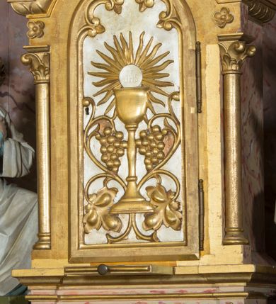 Zdjęcie nr 11: Nastawa ołtarzowa, odpowiadająca formie wnęki, jednoosiowa, jednokondygnacyjna ze zwieńczeniem, na podwójnym cokole. Mensa sarkofagowa, ustawiona na dwóch stopniach, wklęsło-wypukła, zwężająca się ku dołowi. Drewniana z marmurowym portatylem z napisem na odwrocie „Anno Domini MDCCCXCIX Die 1. Augusti Celsissimus ac Reverendissimus Dominus  JOANNES KNIAŹ DE KOZIELSKO PUZYNA Princeps Episcopus Cracoviensis altare hoc portatile consecravit Reliquiasque SS. Corduba et Rogatae Mill inclusit Rog Th Runowski Vice Kustos”. Na mensie ustawiono tabernakulum w formie sześcianu, na cokole, od frontu ujęte kolumnami we wnękach, całość zamknięta gzymsem w formie łuku nadwieszonego. Drzwiczki w profilowanej ramie, dekorowane płaskorzeźbionym przedstawieniem kielicha z hostią w glorii, w otoczeniu kiści winogron i z motywem maswerkowania. Cokół dekorowany trzema płycinami; zewnętrzne w formie stojącego prostokąta, zamkniętego łukiem półkolistym z ornamentem roślinnym; środkowa w formie medalionu z sercem gorejącym. Tabernakulum flankowane przez dwie figury klęczących aniołów, ustawionych na podwójnym cokole, dekorowanym ornamentem roślinnym. Kondygnacja nastawy ujęta dwiema parami kompozytowych kolumn, ustawionych w jednej linii; wewnętrzna para pod kątem. Podpory dźwigają pełne belkowanie, delikatnie wyłamane na ich osiach. W polu środkowym obraz z przedstawieniem Chrystusa u słupa, w profilowanej ramie w formie stojącego prostokąta. Na zasuwie przedstawienie Matki Boskiej Różańcowej ze św. Dominikiem. Pole flankowane przez figury św. Antoniego Padewskiego i św. Franciszka ustawione na niewielkich konsolkach. Na gzymsie płaskorzeźbione Oko Opatrzności w glorii promienistej, z obłokiem. Zwieńczenie w formie czterech kabłąków podtrzymujących diadem zdobiony lambrekinem, ze spływającą po bokach draperią; powyżej cztery kabłąki podtrzymujące krzyż i gorejące serce pośrodku. Cokoły zdobione płycinami z motywem rozet; w jednej trzeciej wysokości trzonów kolumn pierścienie. Fryz zdobiony rozetami. Struktura marmoryzowana w odcieniach jasnego różu i szarości; ornamentyka i detale złocone i srebrzone.