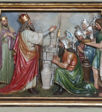 Zdjęcie nr 31: Nastawa ołtarzowa jednokondygnacyjna ze zwieńczeniem, trójosiowa, na cokole. Mensa prostopadłościenna, murowana, w drewnianej obudowie, z kamiennym blatem. Antepedium podzielone na trzy pola, wydzielone czterema kolumienkami. Zewnętrzne płyciny w formie leżącego prostokąta, z płaskorzeźbionymi przedstawieniami po lewej stronie ofiara Melchizedeka, po prawej ofiara Abrahama. W polu środkowym płycina w formie kwadratu, z stylizowanym maswerkowaniem i równoramiennym krzyżem pośrodku oraz rozetami w narożach. Na mensie tabernakulum na wysokiej, prostopadłościennej podstawie, w której znajdują się drzwiczki dekorowane hostią w glorii, flankowane pilastrami z dekoracją  ornamentem arabeskowym. Na osi tron wystawienia w formie niszy ujęty parą smukłych kolumienek podtrzymujących szerokie belkowanie przechodzące nad niszą w łuk. Gzyms wieńczy ornament roślinny, na środku na cokole postać baranka w glorii na księdze z siedmioma pieczęciami. Predella podzielona na trzy pola z występującymi do przodu dwiema niszami z figurami klęczących aniołów. W polach zewnętrznych trzy arkadki z płaskorzeźbionymi przedstawieniami świętych. W polu środkowym tabernakulum flankowane przed dwie arkadki z przedstawieniami świętych. Pierwsza kondygnacja utworzona z trzech arkad wydzielonych kolumnami, oś środkowa wyższa od bocznych. W polu środkowym obraz z przedstawieniem Najświętszego Serca Jezusa, w profilowanej ramie; archiwolta ujęta kolumienkami. Całość zamknięta silnie wysuniętym gzymsem o fantazyjnej linii. W osiach bocznych aedicule z posągami św. Piotra i św. Pawła, zwieńczone daszkiem z latarniami. Kondygnacja flankowana wielobocznymi wspornikami z figurami aniołów. Zwieńczenie w formie aediculi ujętej kolumienkami we wnękach oraz otwartymi półarkadami. Całość zamknięta gzymsem o fantazyjnej linii oraz krzyżem. W niszy figura Matki Boskiej z Dzieciątkiem. Cokoły zdobione płycinami z malowaną i złoconą dekoracja roślinną. Rama obrazu w polu środkowym dekorowana ornamentem roślinno-geometrycznym; archiwolta ornamentem roślinnym w formie liści. Powyżej płycina w kształcie łuku odcinkowego z rzeźbionym ornamentem roślinnym. Archiwolty arkad na osiach bocznych dekorowane ornamentem geometrycznym i stylizowanymi żabkami, w przyłuczach rozety; latarnie zdobione ornamentem roślinnym i stylizowanymi żabkami. Struktura polichromowana w kolorze kości słoniowej i szarym; płyciny i profilowania w kolorze czerwonym oraz zielonym, elementy dekoracyjne złocone.