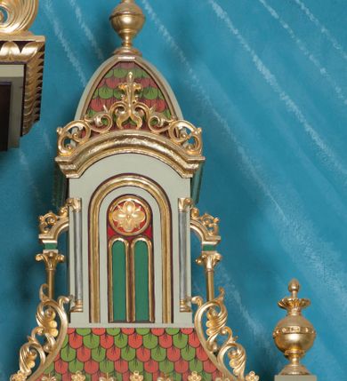 Zdjęcie nr 6: Nastawa ołtarzowa jednokondygnacyjna ze zwieńczeniem, trójosiowa, na cokole. Mensa prostopadłościenna, murowana, w drewnianej obudowie, z kamiennym blatem. Antepedium podzielone na trzy pola, wydzielone czterema kolumienkami. Zewnętrzne płyciny w formie leżącego prostokąta, z płaskorzeźbionymi przedstawieniami po lewej stronie ofiara Melchizedeka, po prawej ofiara Abrahama. W polu środkowym płycina w formie kwadratu, z stylizowanym maswerkowaniem i równoramiennym krzyżem pośrodku oraz rozetami w narożach. Na mensie tabernakulum na wysokiej, prostopadłościennej podstawie, w której znajdują się drzwiczki dekorowane hostią w glorii, flankowane pilastrami z dekoracją  ornamentem arabeskowym. Na osi tron wystawienia w formie niszy ujęty parą smukłych kolumienek podtrzymujących szerokie belkowanie przechodzące nad niszą w łuk. Gzyms wieńczy ornament roślinny, na środku na cokole postać baranka w glorii na księdze z siedmioma pieczęciami. Predella podzielona na trzy pola z występującymi do przodu dwiema niszami z figurami klęczących aniołów. W polach zewnętrznych trzy arkadki z płaskorzeźbionymi przedstawieniami świętych. W polu środkowym tabernakulum flankowane przed dwie arkadki z przedstawieniami świętych. Pierwsza kondygnacja utworzona z trzech arkad wydzielonych kolumnami, oś środkowa wyższa od bocznych. W polu środkowym obraz z przedstawieniem Najświętszego Serca Jezusa, w profilowanej ramie; archiwolta ujęta kolumienkami. Całość zamknięta silnie wysuniętym gzymsem o fantazyjnej linii. W osiach bocznych aedicule z posągami św. Piotra i św. Pawła, zwieńczone daszkiem z latarniami. Kondygnacja flankowana wielobocznymi wspornikami z figurami aniołów. Zwieńczenie w formie aediculi ujętej kolumienkami we wnękach oraz otwartymi półarkadami. Całość zamknięta gzymsem o fantazyjnej linii oraz krzyżem. W niszy figura Matki Boskiej z Dzieciątkiem. Cokoły zdobione płycinami z malowaną i złoconą dekoracja roślinną. Rama obrazu w polu środkowym dekorowana ornamentem roślinno-geometrycznym; archiwolta ornamentem roślinnym w formie liści. Powyżej płycina w kształcie łuku odcinkowego z rzeźbionym ornamentem roślinnym. Archiwolty arkad na osiach bocznych dekorowane ornamentem geometrycznym i stylizowanymi żabkami, w przyłuczach rozety; latarnie zdobione ornamentem roślinnym i stylizowanymi żabkami. Struktura polichromowana w kolorze kości słoniowej i szarym; płyciny i profilowania w kolorze czerwonym oraz zielonym, elementy dekoracyjne złocone.