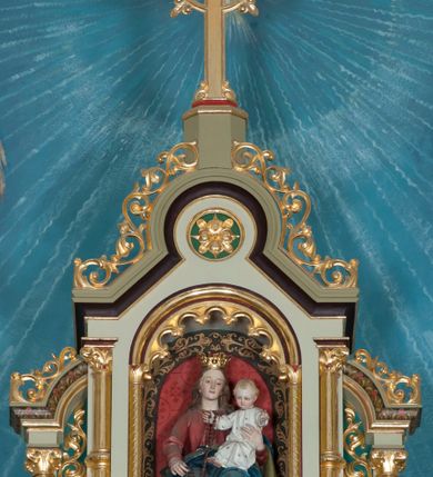 Zdjęcie nr 5: Nastawa ołtarzowa jednokondygnacyjna ze zwieńczeniem, trójosiowa, na cokole. Mensa prostopadłościenna, murowana, w drewnianej obudowie, z kamiennym blatem. Antepedium podzielone na trzy pola, wydzielone czterema kolumienkami. Zewnętrzne płyciny w formie leżącego prostokąta, z płaskorzeźbionymi przedstawieniami po lewej stronie ofiara Melchizedeka, po prawej ofiara Abrahama. W polu środkowym płycina w formie kwadratu, z stylizowanym maswerkowaniem i równoramiennym krzyżem pośrodku oraz rozetami w narożach. Na mensie tabernakulum na wysokiej, prostopadłościennej podstawie, w której znajdują się drzwiczki dekorowane hostią w glorii, flankowane pilastrami z dekoracją  ornamentem arabeskowym. Na osi tron wystawienia w formie niszy ujęty parą smukłych kolumienek podtrzymujących szerokie belkowanie przechodzące nad niszą w łuk. Gzyms wieńczy ornament roślinny, na środku na cokole postać baranka w glorii na księdze z siedmioma pieczęciami. Predella podzielona na trzy pola z występującymi do przodu dwiema niszami z figurami klęczących aniołów. W polach zewnętrznych trzy arkadki z płaskorzeźbionymi przedstawieniami świętych. W polu środkowym tabernakulum flankowane przed dwie arkadki z przedstawieniami świętych. Pierwsza kondygnacja utworzona z trzech arkad wydzielonych kolumnami, oś środkowa wyższa od bocznych. W polu środkowym obraz z przedstawieniem Najświętszego Serca Jezusa, w profilowanej ramie; archiwolta ujęta kolumienkami. Całość zamknięta silnie wysuniętym gzymsem o fantazyjnej linii. W osiach bocznych aedicule z posągami św. Piotra i św. Pawła, zwieńczone daszkiem z latarniami. Kondygnacja flankowana wielobocznymi wspornikami z figurami aniołów. Zwieńczenie w formie aediculi ujętej kolumienkami we wnękach oraz otwartymi półarkadami. Całość zamknięta gzymsem o fantazyjnej linii oraz krzyżem. W niszy figura Matki Boskiej z Dzieciątkiem. Cokoły zdobione płycinami z malowaną i złoconą dekoracja roślinną. Rama obrazu w polu środkowym dekorowana ornamentem roślinno-geometrycznym; archiwolta ornamentem roślinnym w formie liści. Powyżej płycina w kształcie łuku odcinkowego z rzeźbionym ornamentem roślinnym. Archiwolty arkad na osiach bocznych dekorowane ornamentem geometrycznym i stylizowanymi żabkami, w przyłuczach rozety; latarnie zdobione ornamentem roślinnym i stylizowanymi żabkami. Struktura polichromowana w kolorze kości słoniowej i szarym; płyciny i profilowania w kolorze czerwonym oraz zielonym, elementy dekoracyjne złocone.