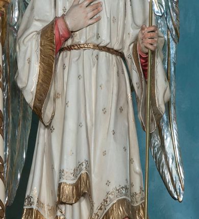 Zdjęcie nr 11: Nastawa ołtarzowa jednokondygnacyjna ze zwieńczeniem, trójosiowa, na cokole. Mensa prostopadłościenna, murowana, w drewnianej obudowie, z kamiennym blatem. Antepedium podzielone na trzy pola, wydzielone czterema kolumienkami. Zewnętrzne płyciny w formie leżącego prostokąta, z płaskorzeźbionymi przedstawieniami po lewej stronie ofiara Melchizedeka, po prawej ofiara Abrahama. W polu środkowym płycina w formie kwadratu, z stylizowanym maswerkowaniem i równoramiennym krzyżem pośrodku oraz rozetami w narożach. Na mensie tabernakulum na wysokiej, prostopadłościennej podstawie, w której znajdują się drzwiczki dekorowane hostią w glorii, flankowane pilastrami z dekoracją  ornamentem arabeskowym. Na osi tron wystawienia w formie niszy ujęty parą smukłych kolumienek podtrzymujących szerokie belkowanie przechodzące nad niszą w łuk. Gzyms wieńczy ornament roślinny, na środku na cokole postać baranka w glorii na księdze z siedmioma pieczęciami. Predella podzielona na trzy pola z występującymi do przodu dwiema niszami z figurami klęczących aniołów. W polach zewnętrznych trzy arkadki z płaskorzeźbionymi przedstawieniami świętych. W polu środkowym tabernakulum flankowane przed dwie arkadki z przedstawieniami świętych. Pierwsza kondygnacja utworzona z trzech arkad wydzielonych kolumnami, oś środkowa wyższa od bocznych. W polu środkowym obraz z przedstawieniem Najświętszego Serca Jezusa, w profilowanej ramie; archiwolta ujęta kolumienkami. Całość zamknięta silnie wysuniętym gzymsem o fantazyjnej linii. W osiach bocznych aedicule z posągami św. Piotra i św. Pawła, zwieńczone daszkiem z latarniami. Kondygnacja flankowana wielobocznymi wspornikami z figurami aniołów. Zwieńczenie w formie aediculi ujętej kolumienkami we wnękach oraz otwartymi półarkadami. Całość zamknięta gzymsem o fantazyjnej linii oraz krzyżem. W niszy figura Matki Boskiej z Dzieciątkiem. Cokoły zdobione płycinami z malowaną i złoconą dekoracja roślinną. Rama obrazu w polu środkowym dekorowana ornamentem roślinno-geometrycznym; archiwolta ornamentem roślinnym w formie liści. Powyżej płycina w kształcie łuku odcinkowego z rzeźbionym ornamentem roślinnym. Archiwolty arkad na osiach bocznych dekorowane ornamentem geometrycznym i stylizowanymi żabkami, w przyłuczach rozety; latarnie zdobione ornamentem roślinnym i stylizowanymi żabkami. Struktura polichromowana w kolorze kości słoniowej i szarym; płyciny i profilowania w kolorze czerwonym oraz zielonym, elementy dekoracyjne złocone.