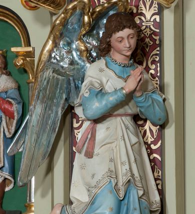 Zdjęcie nr 18: Nastawa ołtarzowa jednokondygnacyjna ze zwieńczeniem, trójosiowa, na cokole. Mensa prostopadłościenna, murowana, w drewnianej obudowie, z kamiennym blatem. Antepedium podzielone na trzy pola, wydzielone czterema kolumienkami. Zewnętrzne płyciny w formie leżącego prostokąta, z płaskorzeźbionymi przedstawieniami po lewej stronie ofiara Melchizedeka, po prawej ofiara Abrahama. W polu środkowym płycina w formie kwadratu, z stylizowanym maswerkowaniem i równoramiennym krzyżem pośrodku oraz rozetami w narożach. Na mensie tabernakulum na wysokiej, prostopadłościennej podstawie, w której znajdują się drzwiczki dekorowane hostią w glorii, flankowane pilastrami z dekoracją  ornamentem arabeskowym. Na osi tron wystawienia w formie niszy ujęty parą smukłych kolumienek podtrzymujących szerokie belkowanie przechodzące nad niszą w łuk. Gzyms wieńczy ornament roślinny, na środku na cokole postać baranka w glorii na księdze z siedmioma pieczęciami. Predella podzielona na trzy pola z występującymi do przodu dwiema niszami z figurami klęczących aniołów. W polach zewnętrznych trzy arkadki z płaskorzeźbionymi przedstawieniami świętych. W polu środkowym tabernakulum flankowane przed dwie arkadki z przedstawieniami świętych. Pierwsza kondygnacja utworzona z trzech arkad wydzielonych kolumnami, oś środkowa wyższa od bocznych. W polu środkowym obraz z przedstawieniem Najświętszego Serca Jezusa, w profilowanej ramie; archiwolta ujęta kolumienkami. Całość zamknięta silnie wysuniętym gzymsem o fantazyjnej linii. W osiach bocznych aedicule z posągami św. Piotra i św. Pawła, zwieńczone daszkiem z latarniami. Kondygnacja flankowana wielobocznymi wspornikami z figurami aniołów. Zwieńczenie w formie aediculi ujętej kolumienkami we wnękach oraz otwartymi półarkadami. Całość zamknięta gzymsem o fantazyjnej linii oraz krzyżem. W niszy figura Matki Boskiej z Dzieciątkiem. Cokoły zdobione płycinami z malowaną i złoconą dekoracja roślinną. Rama obrazu w polu środkowym dekorowana ornamentem roślinno-geometrycznym; archiwolta ornamentem roślinnym w formie liści. Powyżej płycina w kształcie łuku odcinkowego z rzeźbionym ornamentem roślinnym. Archiwolty arkad na osiach bocznych dekorowane ornamentem geometrycznym i stylizowanymi żabkami, w przyłuczach rozety; latarnie zdobione ornamentem roślinnym i stylizowanymi żabkami. Struktura polichromowana w kolorze kości słoniowej i szarym; płyciny i profilowania w kolorze czerwonym oraz zielonym, elementy dekoracyjne złocone.