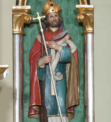 Zdjęcie nr 17: Nastawa ołtarzowa jednokondygnacyjna ze zwieńczeniem, trójosiowa, na cokole. Mensa prostopadłościenna, murowana, w drewnianej obudowie, z kamiennym blatem. Antepedium podzielone na trzy pola, wydzielone czterema kolumienkami. Zewnętrzne płyciny w formie leżącego prostokąta, z płaskorzeźbionymi przedstawieniami po lewej stronie ofiara Melchizedeka, po prawej ofiara Abrahama. W polu środkowym płycina w formie kwadratu, z stylizowanym maswerkowaniem i równoramiennym krzyżem pośrodku oraz rozetami w narożach. Na mensie tabernakulum na wysokiej, prostopadłościennej podstawie, w której znajdują się drzwiczki dekorowane hostią w glorii, flankowane pilastrami z dekoracją  ornamentem arabeskowym. Na osi tron wystawienia w formie niszy ujęty parą smukłych kolumienek podtrzymujących szerokie belkowanie przechodzące nad niszą w łuk. Gzyms wieńczy ornament roślinny, na środku na cokole postać baranka w glorii na księdze z siedmioma pieczęciami. Predella podzielona na trzy pola z występującymi do przodu dwiema niszami z figurami klęczących aniołów. W polach zewnętrznych trzy arkadki z płaskorzeźbionymi przedstawieniami świętych. W polu środkowym tabernakulum flankowane przed dwie arkadki z przedstawieniami świętych. Pierwsza kondygnacja utworzona z trzech arkad wydzielonych kolumnami, oś środkowa wyższa od bocznych. W polu środkowym obraz z przedstawieniem Najświętszego Serca Jezusa, w profilowanej ramie; archiwolta ujęta kolumienkami. Całość zamknięta silnie wysuniętym gzymsem o fantazyjnej linii. W osiach bocznych aedicule z posągami św. Piotra i św. Pawła, zwieńczone daszkiem z latarniami. Kondygnacja flankowana wielobocznymi wspornikami z figurami aniołów. Zwieńczenie w formie aediculi ujętej kolumienkami we wnękach oraz otwartymi półarkadami. Całość zamknięta gzymsem o fantazyjnej linii oraz krzyżem. W niszy figura Matki Boskiej z Dzieciątkiem. Cokoły zdobione płycinami z malowaną i złoconą dekoracja roślinną. Rama obrazu w polu środkowym dekorowana ornamentem roślinno-geometrycznym; archiwolta ornamentem roślinnym w formie liści. Powyżej płycina w kształcie łuku odcinkowego z rzeźbionym ornamentem roślinnym. Archiwolty arkad na osiach bocznych dekorowane ornamentem geometrycznym i stylizowanymi żabkami, w przyłuczach rozety; latarnie zdobione ornamentem roślinnym i stylizowanymi żabkami. Struktura polichromowana w kolorze kości słoniowej i szarym; płyciny i profilowania w kolorze czerwonym oraz zielonym, elementy dekoracyjne złocone.