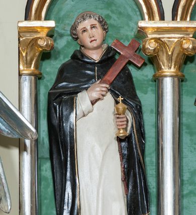 Zdjęcie nr 25: Nastawa ołtarzowa jednokondygnacyjna ze zwieńczeniem, trójosiowa, na cokole. Mensa prostopadłościenna, murowana, w drewnianej obudowie, z kamiennym blatem. Antepedium podzielone na trzy pola, wydzielone czterema kolumienkami. Zewnętrzne płyciny w formie leżącego prostokąta, z płaskorzeźbionymi przedstawieniami po lewej stronie ofiara Melchizedeka, po prawej ofiara Abrahama. W polu środkowym płycina w formie kwadratu, z stylizowanym maswerkowaniem i równoramiennym krzyżem pośrodku oraz rozetami w narożach. Na mensie tabernakulum na wysokiej, prostopadłościennej podstawie, w której znajdują się drzwiczki dekorowane hostią w glorii, flankowane pilastrami z dekoracją  ornamentem arabeskowym. Na osi tron wystawienia w formie niszy ujęty parą smukłych kolumienek podtrzymujących szerokie belkowanie przechodzące nad niszą w łuk. Gzyms wieńczy ornament roślinny, na środku na cokole postać baranka w glorii na księdze z siedmioma pieczęciami. Predella podzielona na trzy pola z występującymi do przodu dwiema niszami z figurami klęczących aniołów. W polach zewnętrznych trzy arkadki z płaskorzeźbionymi przedstawieniami świętych. W polu środkowym tabernakulum flankowane przed dwie arkadki z przedstawieniami świętych. Pierwsza kondygnacja utworzona z trzech arkad wydzielonych kolumnami, oś środkowa wyższa od bocznych. W polu środkowym obraz z przedstawieniem Najświętszego Serca Jezusa, w profilowanej ramie; archiwolta ujęta kolumienkami. Całość zamknięta silnie wysuniętym gzymsem o fantazyjnej linii. W osiach bocznych aedicule z posągami św. Piotra i św. Pawła, zwieńczone daszkiem z latarniami. Kondygnacja flankowana wielobocznymi wspornikami z figurami aniołów. Zwieńczenie w formie aediculi ujętej kolumienkami we wnękach oraz otwartymi półarkadami. Całość zamknięta gzymsem o fantazyjnej linii oraz krzyżem. W niszy figura Matki Boskiej z Dzieciątkiem. Cokoły zdobione płycinami z malowaną i złoconą dekoracja roślinną. Rama obrazu w polu środkowym dekorowana ornamentem roślinno-geometrycznym; archiwolta ornamentem roślinnym w formie liści. Powyżej płycina w kształcie łuku odcinkowego z rzeźbionym ornamentem roślinnym. Archiwolty arkad na osiach bocznych dekorowane ornamentem geometrycznym i stylizowanymi żabkami, w przyłuczach rozety; latarnie zdobione ornamentem roślinnym i stylizowanymi żabkami. Struktura polichromowana w kolorze kości słoniowej i szarym; płyciny i profilowania w kolorze czerwonym oraz zielonym, elementy dekoracyjne złocone.