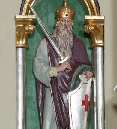 Zdjęcie nr 16: Nastawa ołtarzowa jednokondygnacyjna ze zwieńczeniem, trójosiowa, na cokole. Mensa prostopadłościenna, murowana, w drewnianej obudowie, z kamiennym blatem. Antepedium podzielone na trzy pola, wydzielone czterema kolumienkami. Zewnętrzne płyciny w formie leżącego prostokąta, z płaskorzeźbionymi przedstawieniami po lewej stronie ofiara Melchizedeka, po prawej ofiara Abrahama. W polu środkowym płycina w formie kwadratu, z stylizowanym maswerkowaniem i równoramiennym krzyżem pośrodku oraz rozetami w narożach. Na mensie tabernakulum na wysokiej, prostopadłościennej podstawie, w której znajdują się drzwiczki dekorowane hostią w glorii, flankowane pilastrami z dekoracją  ornamentem arabeskowym. Na osi tron wystawienia w formie niszy ujęty parą smukłych kolumienek podtrzymujących szerokie belkowanie przechodzące nad niszą w łuk. Gzyms wieńczy ornament roślinny, na środku na cokole postać baranka w glorii na księdze z siedmioma pieczęciami. Predella podzielona na trzy pola z występującymi do przodu dwiema niszami z figurami klęczących aniołów. W polach zewnętrznych trzy arkadki z płaskorzeźbionymi przedstawieniami świętych. W polu środkowym tabernakulum flankowane przed dwie arkadki z przedstawieniami świętych. Pierwsza kondygnacja utworzona z trzech arkad wydzielonych kolumnami, oś środkowa wyższa od bocznych. W polu środkowym obraz z przedstawieniem Najświętszego Serca Jezusa, w profilowanej ramie; archiwolta ujęta kolumienkami. Całość zamknięta silnie wysuniętym gzymsem o fantazyjnej linii. W osiach bocznych aedicule z posągami św. Piotra i św. Pawła, zwieńczone daszkiem z latarniami. Kondygnacja flankowana wielobocznymi wspornikami z figurami aniołów. Zwieńczenie w formie aediculi ujętej kolumienkami we wnękach oraz otwartymi półarkadami. Całość zamknięta gzymsem o fantazyjnej linii oraz krzyżem. W niszy figura Matki Boskiej z Dzieciątkiem. Cokoły zdobione płycinami z malowaną i złoconą dekoracja roślinną. Rama obrazu w polu środkowym dekorowana ornamentem roślinno-geometrycznym; archiwolta ornamentem roślinnym w formie liści. Powyżej płycina w kształcie łuku odcinkowego z rzeźbionym ornamentem roślinnym. Archiwolty arkad na osiach bocznych dekorowane ornamentem geometrycznym i stylizowanymi żabkami, w przyłuczach rozety; latarnie zdobione ornamentem roślinnym i stylizowanymi żabkami. Struktura polichromowana w kolorze kości słoniowej i szarym; płyciny i profilowania w kolorze czerwonym oraz zielonym, elementy dekoracyjne złocone.