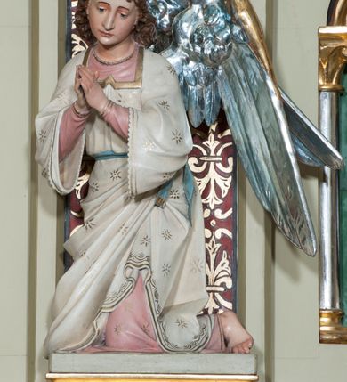 Zdjęcie nr 24: Nastawa ołtarzowa jednokondygnacyjna ze zwieńczeniem, trójosiowa, na cokole. Mensa prostopadłościenna, murowana, w drewnianej obudowie, z kamiennym blatem. Antepedium podzielone na trzy pola, wydzielone czterema kolumienkami. Zewnętrzne płyciny w formie leżącego prostokąta, z płaskorzeźbionymi przedstawieniami po lewej stronie ofiara Melchizedeka, po prawej ofiara Abrahama. W polu środkowym płycina w formie kwadratu, z stylizowanym maswerkowaniem i równoramiennym krzyżem pośrodku oraz rozetami w narożach. Na mensie tabernakulum na wysokiej, prostopadłościennej podstawie, w której znajdują się drzwiczki dekorowane hostią w glorii, flankowane pilastrami z dekoracją  ornamentem arabeskowym. Na osi tron wystawienia w formie niszy ujęty parą smukłych kolumienek podtrzymujących szerokie belkowanie przechodzące nad niszą w łuk. Gzyms wieńczy ornament roślinny, na środku na cokole postać baranka w glorii na księdze z siedmioma pieczęciami. Predella podzielona na trzy pola z występującymi do przodu dwiema niszami z figurami klęczących aniołów. W polach zewnętrznych trzy arkadki z płaskorzeźbionymi przedstawieniami świętych. W polu środkowym tabernakulum flankowane przed dwie arkadki z przedstawieniami świętych. Pierwsza kondygnacja utworzona z trzech arkad wydzielonych kolumnami, oś środkowa wyższa od bocznych. W polu środkowym obraz z przedstawieniem Najświętszego Serca Jezusa, w profilowanej ramie; archiwolta ujęta kolumienkami. Całość zamknięta silnie wysuniętym gzymsem o fantazyjnej linii. W osiach bocznych aedicule z posągami św. Piotra i św. Pawła, zwieńczone daszkiem z latarniami. Kondygnacja flankowana wielobocznymi wspornikami z figurami aniołów. Zwieńczenie w formie aediculi ujętej kolumienkami we wnękach oraz otwartymi półarkadami. Całość zamknięta gzymsem o fantazyjnej linii oraz krzyżem. W niszy figura Matki Boskiej z Dzieciątkiem. Cokoły zdobione płycinami z malowaną i złoconą dekoracja roślinną. Rama obrazu w polu środkowym dekorowana ornamentem roślinno-geometrycznym; archiwolta ornamentem roślinnym w formie liści. Powyżej płycina w kształcie łuku odcinkowego z rzeźbionym ornamentem roślinnym. Archiwolty arkad na osiach bocznych dekorowane ornamentem geometrycznym i stylizowanymi żabkami, w przyłuczach rozety; latarnie zdobione ornamentem roślinnym i stylizowanymi żabkami. Struktura polichromowana w kolorze kości słoniowej i szarym; płyciny i profilowania w kolorze czerwonym oraz zielonym, elementy dekoracyjne złocone.