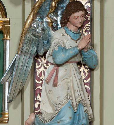 Zdjęcie nr 19: Nastawa ołtarzowa jednokondygnacyjna ze zwieńczeniem, trójosiowa, na cokole. Mensa prostopadłościenna, murowana, w drewnianej obudowie, z kamiennym blatem. Antepedium podzielone na trzy pola, wydzielone czterema kolumienkami. Zewnętrzne płyciny w formie leżącego prostokąta, z płaskorzeźbionymi przedstawieniami po lewej stronie ofiara Melchizedeka, po prawej ofiara Abrahama. W polu środkowym płycina w formie kwadratu, z stylizowanym maswerkowaniem i równoramiennym krzyżem pośrodku oraz rozetami w narożach. Na mensie tabernakulum na wysokiej, prostopadłościennej podstawie, w której znajdują się drzwiczki dekorowane hostią w glorii, flankowane pilastrami z dekoracją  ornamentem arabeskowym. Na osi tron wystawienia w formie niszy ujęty parą smukłych kolumienek podtrzymujących szerokie belkowanie przechodzące nad niszą w łuk. Gzyms wieńczy ornament roślinny, na środku na cokole postać baranka w glorii na księdze z siedmioma pieczęciami. Predella podzielona na trzy pola z występującymi do przodu dwiema niszami z figurami klęczących aniołów. W polach zewnętrznych trzy arkadki z płaskorzeźbionymi przedstawieniami świętych. W polu środkowym tabernakulum flankowane przed dwie arkadki z przedstawieniami świętych. Pierwsza kondygnacja utworzona z trzech arkad wydzielonych kolumnami, oś środkowa wyższa od bocznych. W polu środkowym obraz z przedstawieniem Najświętszego Serca Jezusa, w profilowanej ramie; archiwolta ujęta kolumienkami. Całość zamknięta silnie wysuniętym gzymsem o fantazyjnej linii. W osiach bocznych aedicule z posągami św. Piotra i św. Pawła, zwieńczone daszkiem z latarniami. Kondygnacja flankowana wielobocznymi wspornikami z figurami aniołów. Zwieńczenie w formie aediculi ujętej kolumienkami we wnękach oraz otwartymi półarkadami. Całość zamknięta gzymsem o fantazyjnej linii oraz krzyżem. W niszy figura Matki Boskiej z Dzieciątkiem. Cokoły zdobione płycinami z malowaną i złoconą dekoracja roślinną. Rama obrazu w polu środkowym dekorowana ornamentem roślinno-geometrycznym; archiwolta ornamentem roślinnym w formie liści. Powyżej płycina w kształcie łuku odcinkowego z rzeźbionym ornamentem roślinnym. Archiwolty arkad na osiach bocznych dekorowane ornamentem geometrycznym i stylizowanymi żabkami, w przyłuczach rozety; latarnie zdobione ornamentem roślinnym i stylizowanymi żabkami. Struktura polichromowana w kolorze kości słoniowej i szarym; płyciny i profilowania w kolorze czerwonym oraz zielonym, elementy dekoracyjne złocone.