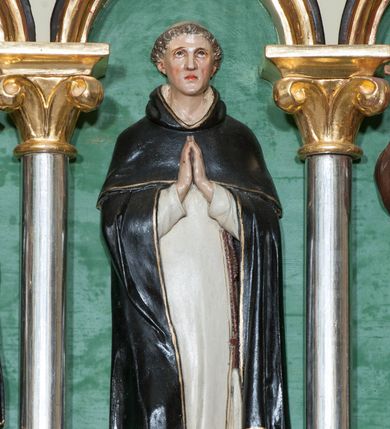 Zdjęcie nr 26: Nastawa ołtarzowa jednokondygnacyjna ze zwieńczeniem, trójosiowa, na cokole. Mensa prostopadłościenna, murowana, w drewnianej obudowie, z kamiennym blatem. Antepedium podzielone na trzy pola, wydzielone czterema kolumienkami. Zewnętrzne płyciny w formie leżącego prostokąta, z płaskorzeźbionymi przedstawieniami po lewej stronie ofiara Melchizedeka, po prawej ofiara Abrahama. W polu środkowym płycina w formie kwadratu, z stylizowanym maswerkowaniem i równoramiennym krzyżem pośrodku oraz rozetami w narożach. Na mensie tabernakulum na wysokiej, prostopadłościennej podstawie, w której znajdują się drzwiczki dekorowane hostią w glorii, flankowane pilastrami z dekoracją  ornamentem arabeskowym. Na osi tron wystawienia w formie niszy ujęty parą smukłych kolumienek podtrzymujących szerokie belkowanie przechodzące nad niszą w łuk. Gzyms wieńczy ornament roślinny, na środku na cokole postać baranka w glorii na księdze z siedmioma pieczęciami. Predella podzielona na trzy pola z występującymi do przodu dwiema niszami z figurami klęczących aniołów. W polach zewnętrznych trzy arkadki z płaskorzeźbionymi przedstawieniami świętych. W polu środkowym tabernakulum flankowane przed dwie arkadki z przedstawieniami świętych. Pierwsza kondygnacja utworzona z trzech arkad wydzielonych kolumnami, oś środkowa wyższa od bocznych. W polu środkowym obraz z przedstawieniem Najświętszego Serca Jezusa, w profilowanej ramie; archiwolta ujęta kolumienkami. Całość zamknięta silnie wysuniętym gzymsem o fantazyjnej linii. W osiach bocznych aedicule z posągami św. Piotra i św. Pawła, zwieńczone daszkiem z latarniami. Kondygnacja flankowana wielobocznymi wspornikami z figurami aniołów. Zwieńczenie w formie aediculi ujętej kolumienkami we wnękach oraz otwartymi półarkadami. Całość zamknięta gzymsem o fantazyjnej linii oraz krzyżem. W niszy figura Matki Boskiej z Dzieciątkiem. Cokoły zdobione płycinami z malowaną i złoconą dekoracja roślinną. Rama obrazu w polu środkowym dekorowana ornamentem roślinno-geometrycznym; archiwolta ornamentem roślinnym w formie liści. Powyżej płycina w kształcie łuku odcinkowego z rzeźbionym ornamentem roślinnym. Archiwolty arkad na osiach bocznych dekorowane ornamentem geometrycznym i stylizowanymi żabkami, w przyłuczach rozety; latarnie zdobione ornamentem roślinnym i stylizowanymi żabkami. Struktura polichromowana w kolorze kości słoniowej i szarym; płyciny i profilowania w kolorze czerwonym oraz zielonym, elementy dekoracyjne złocone.