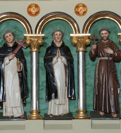 Zdjęcie nr 28: Nastawa ołtarzowa jednokondygnacyjna ze zwieńczeniem, trójosiowa, na cokole. Mensa prostopadłościenna, murowana, w drewnianej obudowie, z kamiennym blatem. Antepedium podzielone na trzy pola, wydzielone czterema kolumienkami. Zewnętrzne płyciny w formie leżącego prostokąta, z płaskorzeźbionymi przedstawieniami po lewej stronie ofiara Melchizedeka, po prawej ofiara Abrahama. W polu środkowym płycina w formie kwadratu, z stylizowanym maswerkowaniem i równoramiennym krzyżem pośrodku oraz rozetami w narożach. Na mensie tabernakulum na wysokiej, prostopadłościennej podstawie, w której znajdują się drzwiczki dekorowane hostią w glorii, flankowane pilastrami z dekoracją  ornamentem arabeskowym. Na osi tron wystawienia w formie niszy ujęty parą smukłych kolumienek podtrzymujących szerokie belkowanie przechodzące nad niszą w łuk. Gzyms wieńczy ornament roślinny, na środku na cokole postać baranka w glorii na księdze z siedmioma pieczęciami. Predella podzielona na trzy pola z występującymi do przodu dwiema niszami z figurami klęczących aniołów. W polach zewnętrznych trzy arkadki z płaskorzeźbionymi przedstawieniami świętych. W polu środkowym tabernakulum flankowane przed dwie arkadki z przedstawieniami świętych. Pierwsza kondygnacja utworzona z trzech arkad wydzielonych kolumnami, oś środkowa wyższa od bocznych. W polu środkowym obraz z przedstawieniem Najświętszego Serca Jezusa, w profilowanej ramie; archiwolta ujęta kolumienkami. Całość zamknięta silnie wysuniętym gzymsem o fantazyjnej linii. W osiach bocznych aedicule z posągami św. Piotra i św. Pawła, zwieńczone daszkiem z latarniami. Kondygnacja flankowana wielobocznymi wspornikami z figurami aniołów. Zwieńczenie w formie aediculi ujętej kolumienkami we wnękach oraz otwartymi półarkadami. Całość zamknięta gzymsem o fantazyjnej linii oraz krzyżem. W niszy figura Matki Boskiej z Dzieciątkiem. Cokoły zdobione płycinami z malowaną i złoconą dekoracja roślinną. Rama obrazu w polu środkowym dekorowana ornamentem roślinno-geometrycznym; archiwolta ornamentem roślinnym w formie liści. Powyżej płycina w kształcie łuku odcinkowego z rzeźbionym ornamentem roślinnym. Archiwolty arkad na osiach bocznych dekorowane ornamentem geometrycznym i stylizowanymi żabkami, w przyłuczach rozety; latarnie zdobione ornamentem roślinnym i stylizowanymi żabkami. Struktura polichromowana w kolorze kości słoniowej i szarym; płyciny i profilowania w kolorze czerwonym oraz zielonym, elementy dekoracyjne złocone.