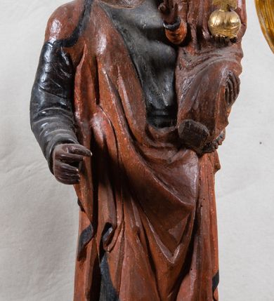 Zdjęcie nr 2: Feretron z figurą Matki Boskiej z Dzieciątkiem umieszczoną pod ozdobnym baldachimem, na prostopadłościennej podstawie. Maria została ukazana całopostaciowo, w lekkim kontrapoście. Prawą rękę trzyma wyciągniętą przed sobą na wysokości pasa; lewą podtrzymuje Dzieciątko. Karnacja Marii i Dzieciątka ciemnobrązowa. Twarz Matki Boskiej owalna, o pełnych policzkach i drobnych regularnych rysach. Maria jest ubrana w ciemnobrązową suknię oraz drapowany, rudy płaszcz z ciemną lamówką. Welon na głowie zaznaczony za pomocą malowanego konturu. Dzieciątko siedzi, stopy ma wyciągnięte przed siebie, prawą rękę unosi w geście błogosławieństwa, w lewej trzyma jabłko królewskie. Twarz małego Jezusa jest owalna, czoło wysokie, okolone ciemnymi puklami. Na głowach Marii i Dzieciątka złote korony zamknięte. Rzeźba wtórnie umieszczona w feretronie – na postumencie, ujęta w cztery ślimacznice łączące się pod okrągłym lambrekinem zwieńczonym promienistą glorią z centralnie umieszczonym monogramem Marii.