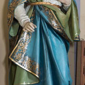 Zdjęcie nr 1: Rzeźba pełna, na cokole, przedstawiająca typ ikonograficzny  Najświętsze Serce Marii. Matka Boska została ukazana całopostaciowo, frontalnie, w lekkim kontrapoście. Głowę ma nieznacznie pochyloną do przodu, karnację jasną, rysy twarzy delikatne, powieki wpółprzymknięte. Jasne, falowane włosy dzielące się w pukle opadają na ramiona i dekolt. Maria jest ubrana w białą suknię przepasaną złotym sznurem. Na ramiona ma zarzucony błękitny, podbity zielenią płaszcz zdobiony przy brzegach złotą lamówką i złotym ornamentem roślinnym, a na głowę biały welon opadający na plecy i ramiona. Prawą rękę przyciska do piersi, na której widoczne gorejące złotym płomieniem, czerwone serce oplecione różanym wieńcem, lewą wyciąga przed siebie. 