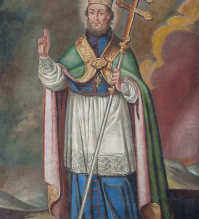 Zdjęcie nr 1: Wizerunek św. Wojciecha na obrazie w kształcie stojącego prostokąta w prostej, profilowanej ramie. Święty przedstawiony całopostaciowo, zwrócony delikatnie w prawą stronę. Ma pociągłą twarz o jasnej karnacji, wąski nos, małe, pełne usta i ciemne, wyraziste oczy. Twarz ma okoloną jasnobrązowymi włosami i krótką brodą; wokół głowy świetlisty nimb. Święty prawą rękę unosi w geście błogosławieństwa, w lewej trzyma podwójny krzyż misyjny. Święty Wojciech został przedstawiony w stroju pontyfikalnym złożonym z ciemnoniebieskiej, długiej sutanny, komży wykończonej u dołu szerokim pasem koronki, almucji w kolorze sutanny i spiętej na piersi zielonej kapy dekorowanej szeroką, złotą bordiurą i podbitej czerwienią. Spod sutanny widać czubki niebieskich butów ze złotymi krzyżami. U stóp świętego, z przodu kompozycji przedstawiono fragment wiosła, a w tle pagórkowaty krajobraz i skłębione fioletowo-niebiesko-żółte obłoki.  