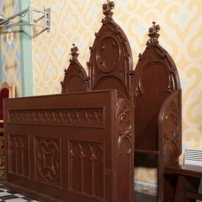 Zdjęcie nr 1: Stalle na rzucie wydłużonego prostokąta, jednorzędowe, trójosiowe. Zaplecek wysoki, trójdzielny, złożony z trzech łuków ostrych, z których środkowy jest najwyższy. Łuki wypełnia ślepe maswerkowanie: w centralnym w formie rozety wypełnionej czworoliściem powyżej arkady, z przyłuczami dekorowanymi trójliśćmi, w bocznych w formie trójliści. Krawędzie łuków są zdobione żabkami, każdy wieńczy kwiaton.  
Siedziska są od przodu poprzedzone ścianką z parapetem, która jest od frontu dekorowana czterema polami. W górnej części w kształcie wąskiego pasa wypełnionego trójliśćmi, w dolnej trzema kwadratowymi polami, z których środkowe wypełnia romb o wklęsłych krawędziach wpisany w czworoliść ujęty w okrąg, a boczne arkadkowanie. Boczne ścianki stalli zdobione motywem czworoliścia wpisanego w okręgi powyżej arkadki. Siedziska nieprzedzielone. Stalla pomalowana na kolor ciemnobrązowy. 
