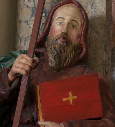 Zdjęcie nr 2: Rzeźba drążona, na cokole. Święty Cyryl został ukazany całopostaciowo, zwrócony nieznacznie w lewo z korpusem przechylonym na tę stronę, w kontrapoście. Ma owalną twarz o jasnej karnacji, wysokim czole, niebieskich oczach o kącikach zewnętrznych opadających w dół, niewielkim prostym nosie i małych ustach; falowana, jasnobrązowa broda opada mu na pierś. Jest ubrany w długi ciemnoczerwony habit przewiązany w pasie, z kapturem założonym na głowę. Habit opada do ziemi, łamiąc się w grube fałdy, spod niego wystają fragmenty butów. Na habit ma zarzucony na prawe ramię, udrapowany płaszcz w kolorze zieleni. W prawej dłoni Cyryl trzyma krzyż misyjny, lewą podtrzymuje rąbek płaszcza i księgę w czerwonej oprawie ze złotym krzyżem. Polichromia w partiach ciała naturalistyczna. 